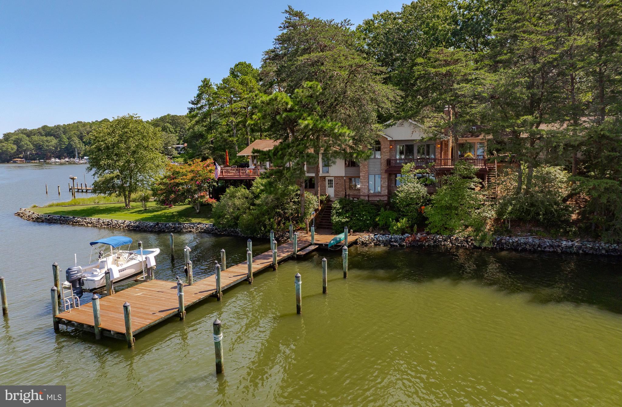 Prepare yourself for a waterfront opportunity like no other. This extremely well-maintained property has several extraordinary attributes, one being, it is not viewable from the street. The property is close to one acre, and boasts 350 feet of rip rapped waterfront, coupled with two piers, both deep water for power and or sailboat,three-car garage for the automobile enthusiast, a master bedroom suite like no other, with attached sunroom, and private deck. The main house offers three additional bedrooms and baths, all with two baths, fireplace, tremendous water views. The main great room has a stone fireplace, vaulted ceilings, and views up and down Mill Creek. The property sits on a point of land, hardscape, well landscaped, piers are in excellent condition, and boat lift for the runabout. Several different entertaining areas throughout the entire property. Again, definitely one-of-a-kind property. Brick front walkway is amazing. Downstairs great room has views up and down Mill Creek also . This property is located in Drum Point. Minutes by boat to Historic Solomons Island the Patuxent river and Chesapeake bay. The Solomons Bridge is viewable from the decks and from the bay windows in the Great Room. It is one hour to Annapolis, one and a half hours to Washington, D.C., and an hour and 15 minutes to International Airport.