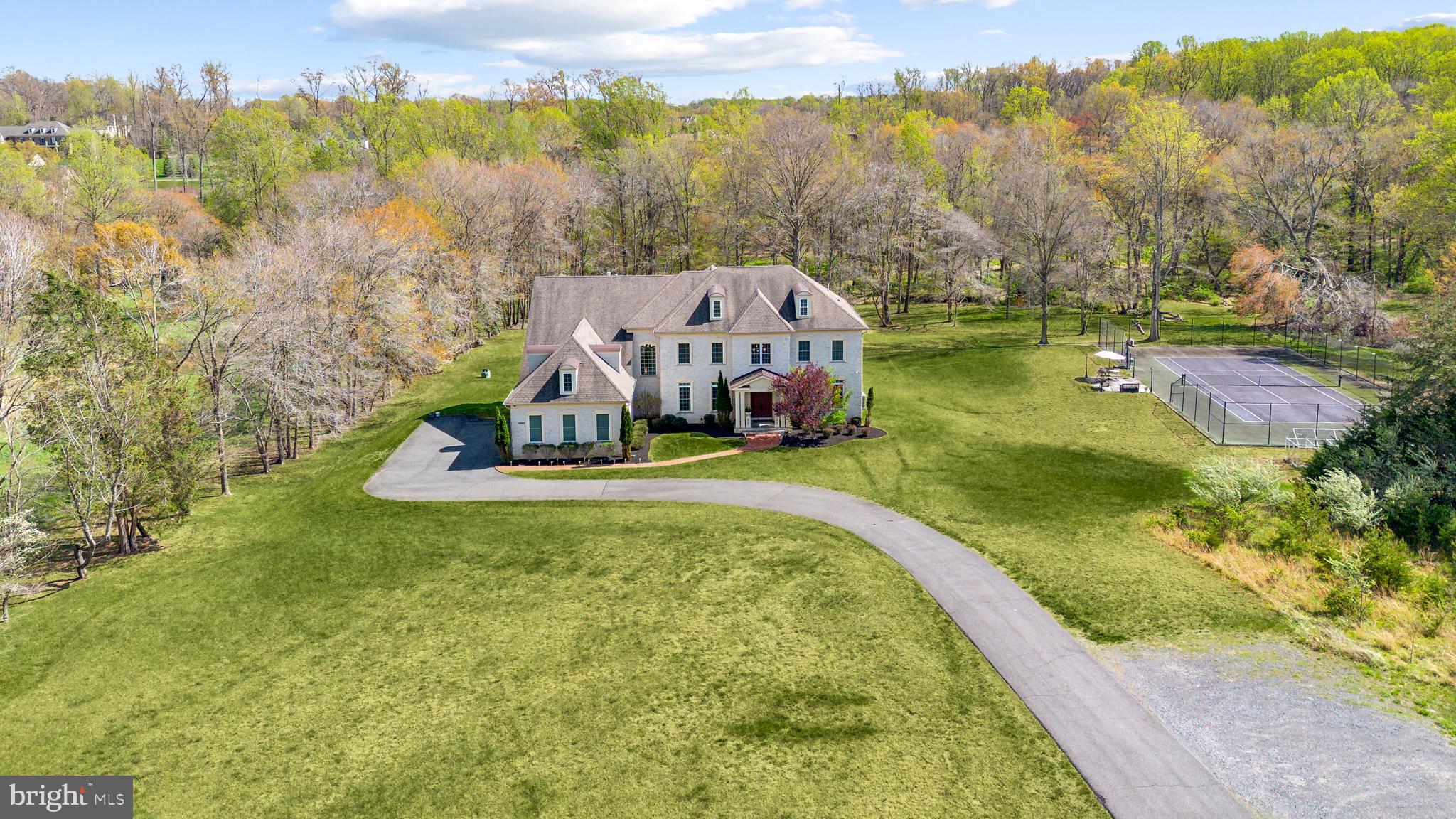 Welcome to Stuart Mill Manor – a breathtaking 5-bedroom, 5 full and 2 half-bath estate that redefines luxury living with high-end finishes, exquisite customizations, and show stopping architectural details at every turn on over 5 acres.
Enter through grand double doors into the dramatic two-story marble foyer, featuring a sky bridge, Juliet balcony, a stunning spiral staircase with intricate custom woodwork, and an opulent chandelier that sets the tone for the home’s elegance. The formal living and dining rooms are framed by stately Roman-style columns, adorned with double chandeliers, intricate crown molding, and rich hardwood floors that flow seamlessly throughout the home.
The chef’s kitchen is a masterclass in design, outfitted in all white with two expansive islands, marble countertops, floor-to-ceiling custom cabinetry, stainless steel appliances, a wet bar, wine cooler, and custom lighting. The space blends function with beauty, making it the perfect heart of the home. Just off the kitchen, a sunlit home office with oversized windows offers a productive escape, while the adjacent richly paneled study features floor-to-ceiling built-ins, a cozy bay window seat, and elegant coffered ceilings. A custom walk-in closet on the main level adds practicality with style.
Upstairs, retreat to the grand primary suite complete with a private living area, floating fireplace, expansive walk-in closet with bespoke built-ins, and a spa-inspired en-suite bath featuring marble flooring, dual vanities, and an oversized walk-in shower. Four additional spacious bedrooms, along with three beautifully appointed full bathrooms, complete the upper level.
The lower level is an entertainer’s dream. Host wine tastings in your brick-walled wine cellar with extensive built-in storage. Enjoy movie nights in the private home theater or gather in the expansive rec room and game area. A fully equipped home gym rounds out this extraordinary space.
Step outside to your private outdoor private oasis, complete with an expansive deck, built-in bar and grill, and unlimited room for seating and entertaining. For sports and recreation, enjoy your very own private tennis court surrounded by lush landscaping.
Parking: Three-car garage with additional driveway space.