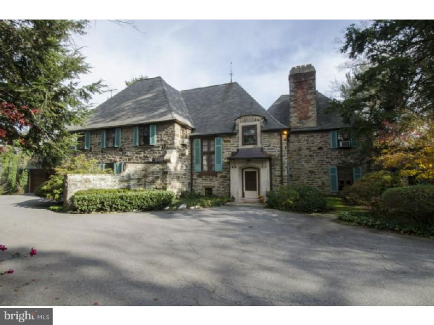 All stone 6 bedroom French Norman Styled home exudes elegance and old world appeal on a picturesque 2.08 acre lot in desired Wynnewood location. Stone Foyer with sweeping wrought iron stair makes for a dramatic entry and offers views to the step down Living Room, Den/Library and formal Dining Room. Handsome dark stained parquetry floors enhance the formal Living space and add contrast to the detailed moldings, oversized wood burning fireplace and three walls of windows. Through a cased opening find the Den/Library, outfitted with a bar and offering french door access to the stone terrace which runs the entire length of the back of the home. Steps away is a gracious Dining Room with wood burning fireplace and exit to Terrace for seamless flow, be it in a formal or al fresco setting. Connecting to the Dining Room is a breakfast area with handy "pass through" to the Rutt kitchen highlighted with seated island and side door exit to the auto courtyard and beyond to the laundry/mudroom and back stairs. Finished lower level is well executed with painted murals of Mexico and themed, tile bar. A wood burning fireplace and large seating area provides additional recreational space. Generous storage and mechanicals  are also found on this level. Ascend the stairs to the second level offering 6+ bedrooms and 5 full baths. Large Master Bedroom is highlighted with Western and Southern facing windows and a wood  burning fireplace on the Northern wall. His and her Baths and a large Dressing room/ Nursery off the "her" side combine to create a deluxe Master Suite. Three other family bedrooms one with en suite bath, the others with shared bath. Travel down the corridor to find the back stair and three additional Bedrooms, two currently purposed as offices and shared hall bath. Beautifully maintained gracious home with sweeping views.