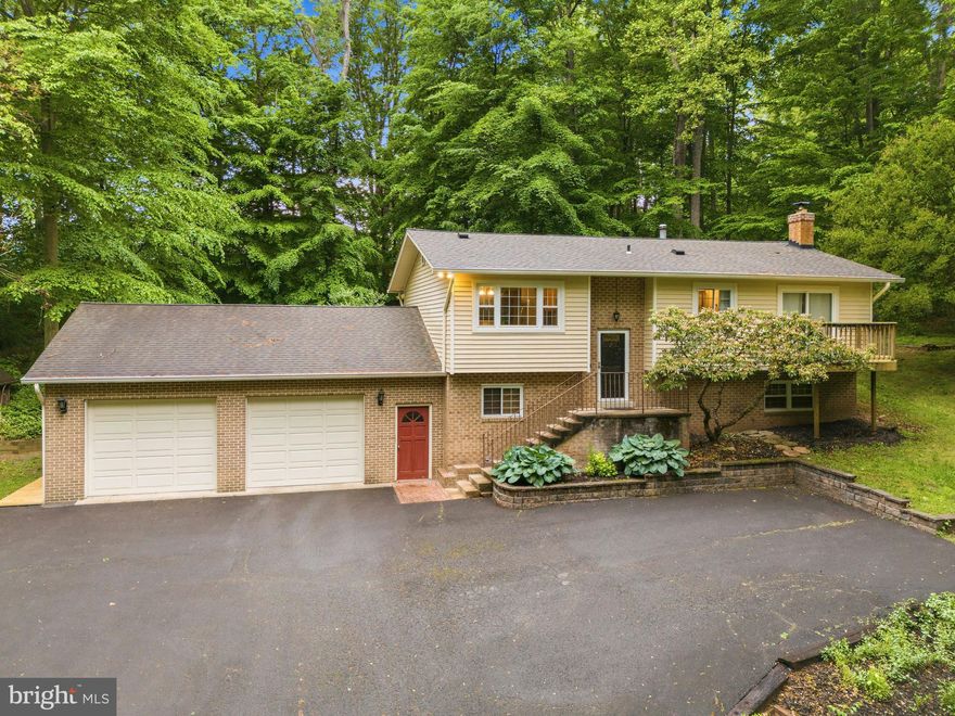 Escape to your own private oasis in the woods! This unique property includes two parcels totaling over 2.36 acres. Please note: 8016 Lake Drive consists of 1.3386 acres and includes the existing home. 8014 Lake Drive consists of 1.0274 acres, fronts the road, and may allow for the construction of a second home.

This spacious single-family home features 4 bedrooms, 3 full updated bathrooms, and an open-concept floor plan. The kitchen offers Corian countertops and stainless steel appliances. Hardwood floors run throughout the living room, hallway, and main level bedrooms. The living room features skylights, and crown molding can be found throughout the home. Fresh neutral paint adds a bright, updated feel.

The main level includes 3 bedrooms and 2 full bathrooms. The lower level features updated luxury vinyl plank flooring, a large family room with wood stove, 4th bedroom, and 3rd full bathroom.

Enjoy peaceful wooded views from the screened-in porch overlooking the scenic backyard, complete with a large deck and hot tub. The attached 896 sq. ft. 2-car garage includes a workshop area and abundant storage, plus an additional 3-car carport on the side of the home. Two storage sheds convey. Roof, siding, and gutters were replaced in 2011. No HOA!