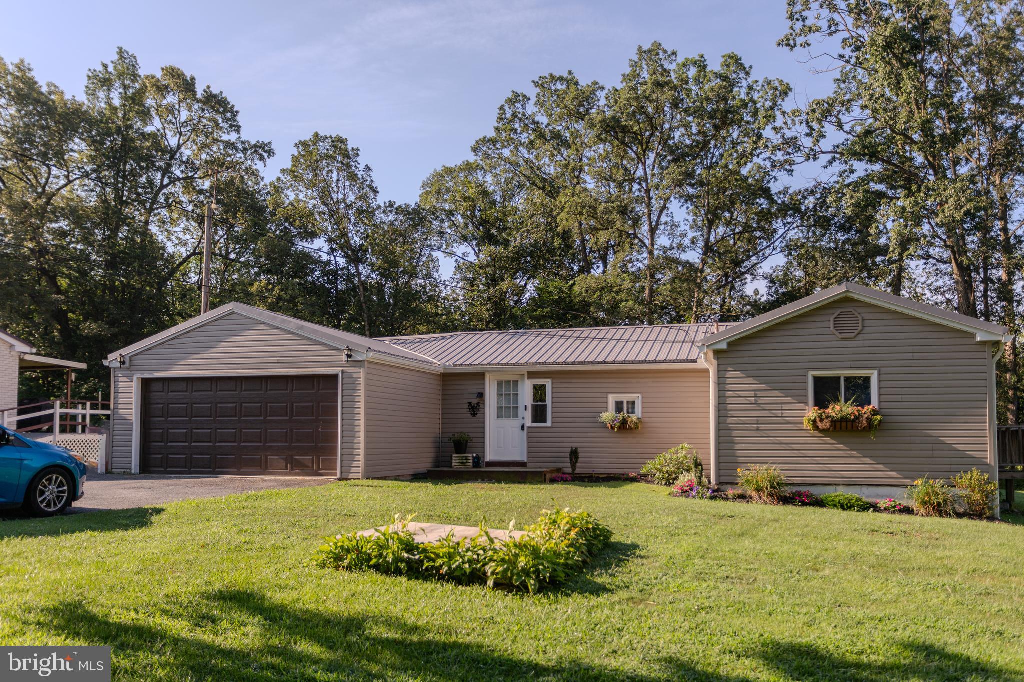 Rural Living with a Creekside Bonus! Looking for something a little different? This home sits on just under an acre of mostly wooded land (.82 to be exact) at the end of a quiet road - so the only cars rolling by are the neighbors. There’s a private balcony off the main bedroom, plus a large deck for relaxing, grilling, or watching the sunset. Out back, a cleared path takes you straight to the stream—perfect for exploring, or just getting some quiet time. It’s peaceful, it’s laid-back, and it’s ready for someone who wants more than just your average house.
