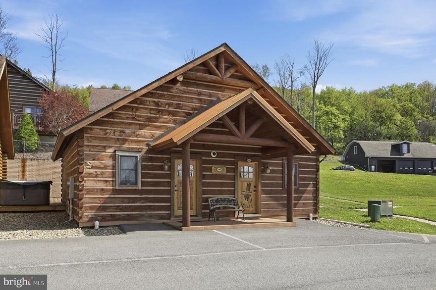 Cabin #40 at The Lodges of Sunset Village is a detached home offering two "lock off" units with a shared door between the units, with 1024 square feet. Each side offers an efficiency-style layout on the main floor with a kitchenette, and a full bath. One side has a king and the other has two queens. This unit also has a deck, hot tub and patio.

Rich in mountain character and charm, this log cabin features uniquely carved wood doors, beautiful beamed ceilings, warm wood walls, and inviting spaces that create an authentic lake and mountain retreat feel. Additional features include lake views, ski slope views, expansive decks and patios, upgraded finishes, open concept living, stacked stone gas fireplace, and open concept living.

Enjoy incredible views of Deep Creek Lake and Wisp, along with front row seats for seasonal beauty and memorable moments, including views of the annual July 4th fireworks. This property has a proven rental history, generating an average of  $72,869  in annual gross rental income, creating an exciting opportunity for buyers seeking both personal enjoyment and investment potential.

Experience one of Deep Creek Lake’s newest ownership opportunities at The Lodges at Sunset Village. For the first time ever, fully furnished lake area cabins are being offered for individual ownership in a breathtaking community featuring incredible lake and Wisp ski slope views. Community amenities include lake access with 10 shared dock slips and an impressive 1,320 square foot waterfront dock area perfect for fishing, swimming, launching kayaks, relaxing by the water, and enjoying summer fun at the lake. Residents and guests also enjoy a lakeside gazebo, playground, fire pit, gathering areas, pet-friendly accommodations, abundant parking, and on-site professional management.

The monthly condo fee provides exceptional convenience, including most utilities, snow removal, trash service, and yard maintenance, for a low-maintenance ownership experience. Whether you're searching for a vacation retreat, income-producing investment, or both, The Lodges at Sunset Village offers a rare opportunity to own at Deep Creek Lake. Stop by our on-site Sales Center at The Lodges Gatehouse during open hours to learn more, explore ownership opportunities, and get your questions answered: Thursdays 2:00–6:00 PM, Fridays 1:00–5:00 PM, Saturdays 10:00 AM–5:00 PM, and Sundays 10:00 AM–2:00 PM or call today for details and your private showing!