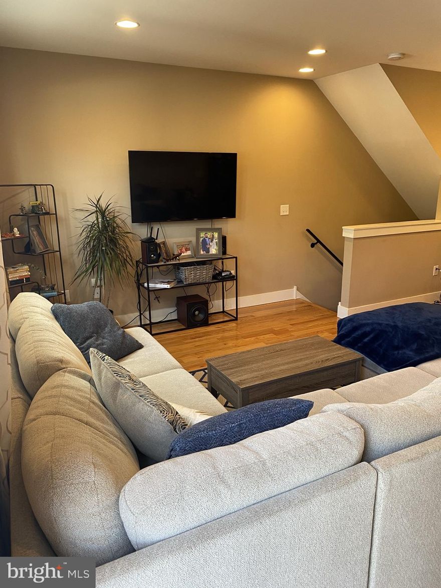 Modern 2 bed/2 bath condo featuring an open floor plan & hardwood flooring throughout. Enter the front door into a nicely sized living room complete with large casement windows allowing for tons of natural light. Kitchen features 42" cabinets, Quartz countertops, tile backsplash, stainless steel appliances, a breakfast bar with a separate adjacent dining area & a pantry closet for extra storage. Second level primary bedroom with ensuite bath and sizable walk-in closet. Lower level complete with additional large bedroom, full bath, laundry, and bonus flex space perfect for a home office, gym, or additional living room. Covered one car parking with access through the kitchen. Close proximity to public transportation/I-95 and all the delicious restaurants Frankford Ave / Front St have to offer!