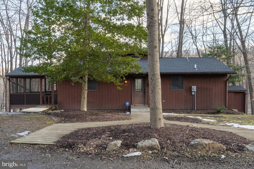 Nestled in the serene COOLFONT MOUNTAINSIDE community, this charming contemporary home offers a perfect blend of comfort and investment potential. Built in 1986, this well-maintained detached residence features 4 spacious bedrooms and 3 full bathrooms, making it an ideal choice for those seeking a lucrative rental opportunity or a cozy retreat. Step inside to discover an inviting open floor plan, highlighted by luxury vinyl plank and tile flooring. The heart of the home is the eat-in kitchen, complete with modern appliances including a dishwasher, electric oven/range, and front-loading washer and dryer. The family room, conveniently located off the kitchen, is perfect for gatherings, while the primary suite boasts a private bath for added convenience. The fully finished basement, with both interior and outside access, offers additional living space or potential for rental income. Enjoy evenings by the wood stove or unwind in the hot tub, surrounded by the tranquility of nature. Outside, the property sits on a generous 0.55-acre lot, featuring a circular gravel driveway and community recreation area and pool access, enhancing its appeal to potential renters. With picturesque views of the lake and surrounding woods, this home not only provides a peaceful retreat but also promises strong rental returns in a desirable location. Berkeley Springs draws visitors throughout the year with its celebrated spa culture, scenic wine trails, and abundant outdoor recreation. Coolfont Resort is located nearby, while Cold Run Valley Winery offers tastings a short drive down the road. Berkeley Springs State Park, known for its natural warm springs, and Cacapon Resort State Park, with its excellent hiking trails, are both easily accessible and give guests plenty of reasons to visit. Don't miss the chance to invest in this inviting property that combines comfort, style, and financial potential.