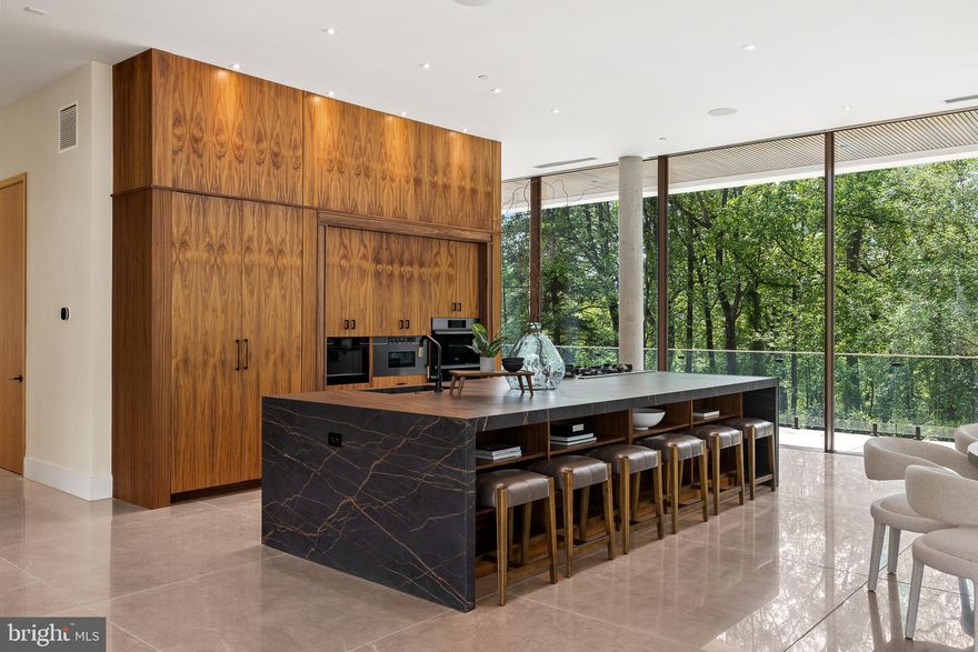 Among first impressions, "This is the finest home ever designed on the Main Line."  A striking 16,000-square-foot statement piece, The Glass House pushes the boundaries of contemporary luxury. Crafted by two visionary architects from Paris, this extraordinary home is a masterful fusion of glass, stone, wood, and steel—thoughtfully integrated into a landscape of mature trees and artfully designed gardens. Tucked away into the greenery overlooking Philadelphia Country Club, the Glass House offers unmatched luxury and privacy. Step inside to discover an interior where design and function are in perfect harmony. A dramatic two-story atrium greets you with an indoor pool as its centerpiece—an awe-inspiring focal point that offers both beauty and year-round enjoyment. The entire first floor is wrapped in warm-toned, large-format stone imported from India, creating a seamless sense of scale and flow throughout the living spaces. Floor-to-ceiling retractable glass panels erase the divide between inside and out, immersing the home in the beauty of its landscaped grounds and infinity-edge pool. At the heart of the home, a striking open-concept kitchen features deeply stained custom wood cabinetry, a massive center island with prep sink and integrated six-burner gas cooktop, sleek appliances and custom shelving. An adjacent indoor atrium brings life and freshness to the space, marrying nature and modernism. Perfectly curated for both grand entertaining and intimate daily living, the first floor is highly amenitized including the indoor pool, huge sauna, stadium tiered home theater and access to the Glass House grounds, which include another outdoor infinity pool. The home offers five luxurious bedroom suites, including a spacious main-level suite—while additional square footage provides the flexibility to create several more bedrooms if desired. The second level is accessible by one of two striking glass and white oak floating staircases, each suite serves as a private retreat, featuring oversized custom closets, Porcelanosa tile bathrooms, and peaceful balconies with views of the surrounding grounds. From the resort caliber amenities to its globally inspired architecture, The Glass House stands in a class of its own. Every inch of this residence reflects an uncompromising commitment to design excellence, craftsmanship, and serenity. Whether hosting unforgettable gatherings beneath the stars or enjoying quiet moments surrounded by nature, this home offers an unparalleled lifestyle experience. Truly, there is nothing else like it on the Main Line. For the discerning buyer who demands the extraordinary ---- Welcome Home.
