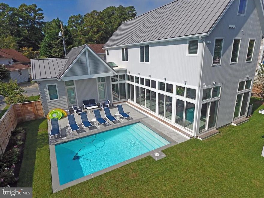 This 5 BR custom home with 22' heated swimming pool was newly constructed in 2017 and offers an exciting blend of coastal beach charm and contemporary style.  It is well located in the Pines section of North Rehoboth, walking distance to the beach, boardwalk, restaurants and shops. The open floor plan is flooded with light as the walls of windows look out onto the pool and yard offering spacious indoor and outdoor living. A state-of-the-art kitchen with polished quartz counters and Bosch appliances opens to the living space.  Special features include 10' ceilings, 2 zone audio  and a private, first floor MBR with direct pool access. Climb the floating staircase to find 4 more BRs (including 2 masters), and a second washer/dryer for convenience. Bonus is an easy-access storage basement (or let the kids play there on a rainy day) and the oversized lot (84x84) allows parking for 6 cars.   Never rented but amazing rental potential for this home--or just keep it for family and friends.