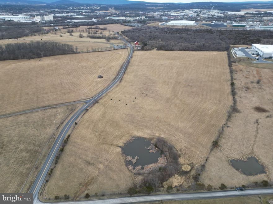 Prime industrial or commercial development site in ideal location on the north side of the Winchester area! This land is already shown as industrial on the county's current future Comprehensive Plan assisting in the rezoning process. Only minutes from Interstate 81, Route 11, and the 37 Bypass.  Extensive asphalt road frontage on state maintained Redbud Road and further gravel road frontage on state maintained Milburn Road. The northern boundary will front on the relocation of Redbud Road creating even more access. Water and sewer mains less than 500 ft away from the property. Electricity service lines are already running on this parcel as well. The surrounding area is covered with industrial businesses and name brand retailers. Rezoning would allow for warehousing, distribution, self-storage warehousing, light or heavy manufacturing, commercial office or heavy commercial operations. This site has it all location, visibility, accessibility, and exposure. Currently zoned Rural Areas (RA). This land is nearly flat, cleared, and currently used to pasture livestock. Don’t miss out!