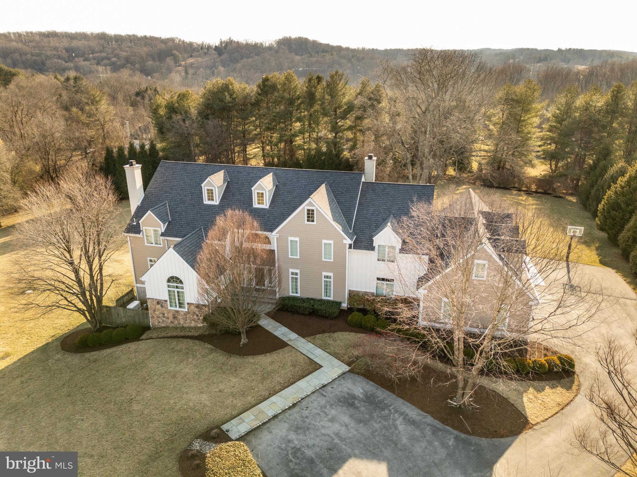 Nestled in the exclusive Birmingham Estates, this breathtaking five-bedroom, four-full and four-half-bathroom home is the epitome of refined living. Set on 3.5 private acres, this hilltop estate offers stunning views, an exceptional layout, and a backyard retreat—all within minutes of West Chester’s vibrant downtown, scenic trails, and top-rated schools.
A grand stone-pillared entrance and winding driveway set the stage for this magnificent home. Inside, a three-story atrium-style staircase welcomes you with soaring ceilings, gleaming hardwood floors, and abundant natural light. Designed for seamless entertaining and everyday comfort, the open-concept layout flows effortlessly from one elegant space to the next. The grand two-story family room features vaulted ceilings and custom built-ins, while the formal living room boasts an inviting fireplace. A sun-drenched sitting room provides another peaceful space to unwind. The heart of the home is the designer chef’s kitchen, a true showstopper with custom cherry cabinetry, premium granite countertops, Wolf and Sub-Zero appliances, and an oversized island. A cozy fireplace and stainless accents add warmth, while the kitchen opens to a sunroom, dining area, and an expansive outdoor patio. Two private home offices offer inspiring views and a quiet setting for remote work.
The second floor is anchored by the luxurious primary suite, a private retreat featuring a spacious sitting area, a spa-like bath with a walk-in shower, and an oversized walk-in closet with a center island. Two additional bedrooms share a beautifully designed Jack-and-Jill bath, while a third guest suite offers a private en-suite. A bright fifth bedroom and a convenient second-floor laundry room complete this level.
The finished third floor offers endless possibilities, making it an ideal space for a home office, yoga studio, or creative retreat.
The lower level is an entertainer’s dream. The finished walkout basement includes a guest suite, a billiards area, a media space, and direct access to the backyard.
The outdoor living space is just as impressive as the interior, with an expansive stone patio, a covered pergola, and a built-in grilling station, all surrounded by beautifully manicured gardens and mature trees. Whether hosting a summer barbecue or enjoying a quiet evening under the stars, this outdoor retreat is truly exceptional. A three-car garage and a driveway basketball hoop add both practicality and fun to an active lifestyle.
With recent high-end updates, including Hardie Board siding in 2021, a new roof in 2018, and updated windows and doors in 2010, this home is move-in ready and built to last. Located in the heart of Wyeth Brandywine country, just minutes from Longwood Gardens, Radley Run Country Club, and downtown West Chester, this home offers the perfect balance of serenity and convenience.
Don’t miss this rare opportunity—schedule your private tour today!