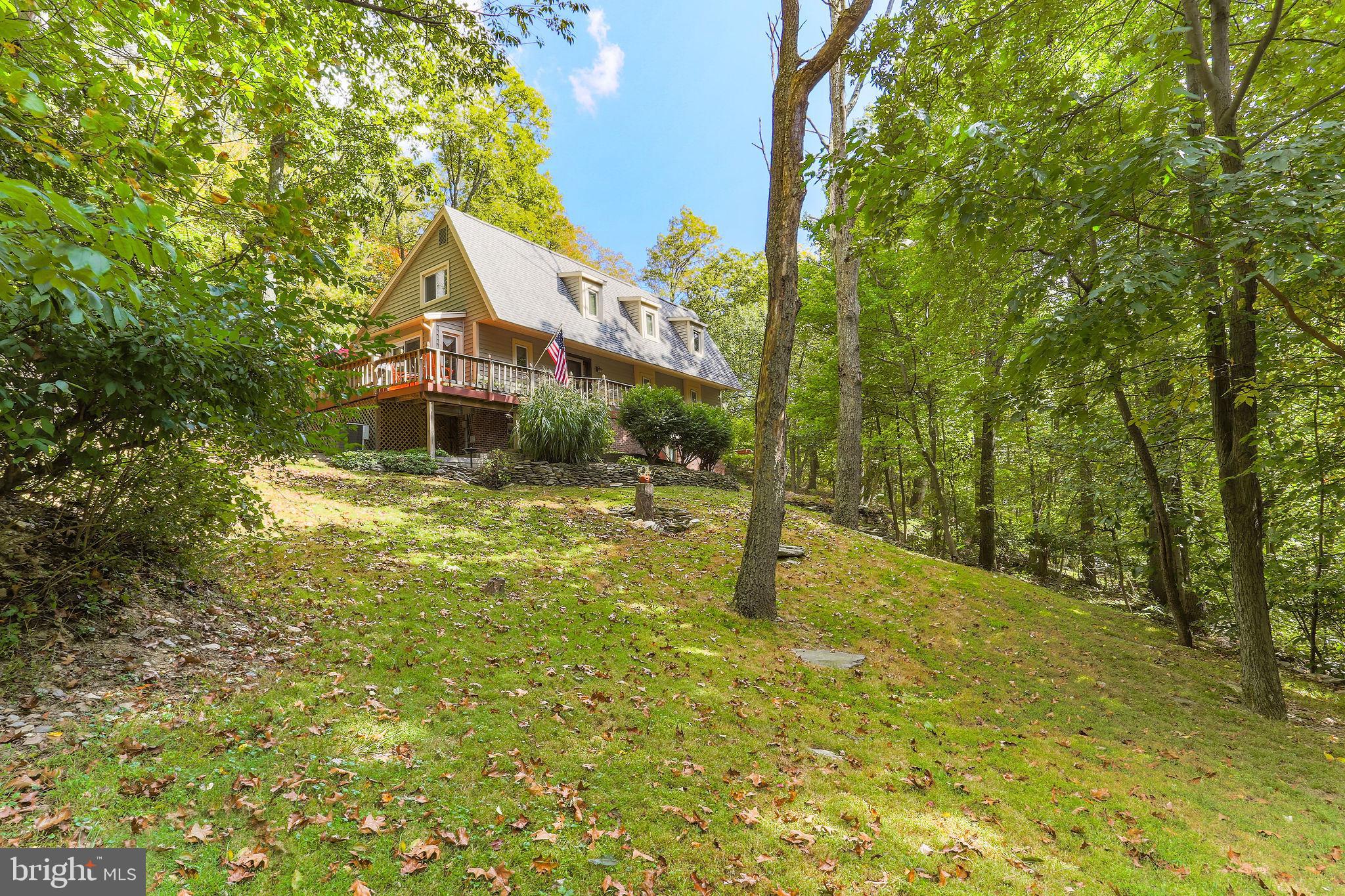 Gorgeous! Custom-built home nestled in a very private, 2-acre, wooded setting in sought after RIDGE CREST ESTATES. Located within Middletown School District. Tastefully designed with an eclectic mix of contemporary style and traditional flair, this home offers hardwood floors throughout! Custom kitchen fully equipped with high-end cabinets, granite counters and top of the line stainless steel appliances including a SUB-ZERO fridge, JENN-AIRE downdraft range and MIELE dishwasher. Family room and dining room areas have soaring, vaulted ceilings with skylights, two oversized picture windows that bring the outdoors inside, a floor to ceiling brick fireplace equipped with a Vermont Castings wood stove insert, that adds a warm, cozy feel and drastically reduces heating costs in winter months and a built-in, BOSE, surround-sound system that adds a theater-like feel to evening entertainment. First floor, oversized, master suite opens to a huge, wrap around deck beautifully landscaped with natural, stacked-stone walls and a pond with a water fountain feature. Fully finished lower level with half bath and cedar lined wine cellar offers an additional opportunity for relaxing and entertaining! Exterior of this home is wrapped in brick and recently installed, high-end, insulated vinyl siding, gutters with leaf guards and newer, energy saving, thermal, maintenance free windows and doors. This is truly a unique, tranquil, and beautiful home filled with character and surrounded by nature that affords charm and privacy that you will not find in a typical, suburban development.
