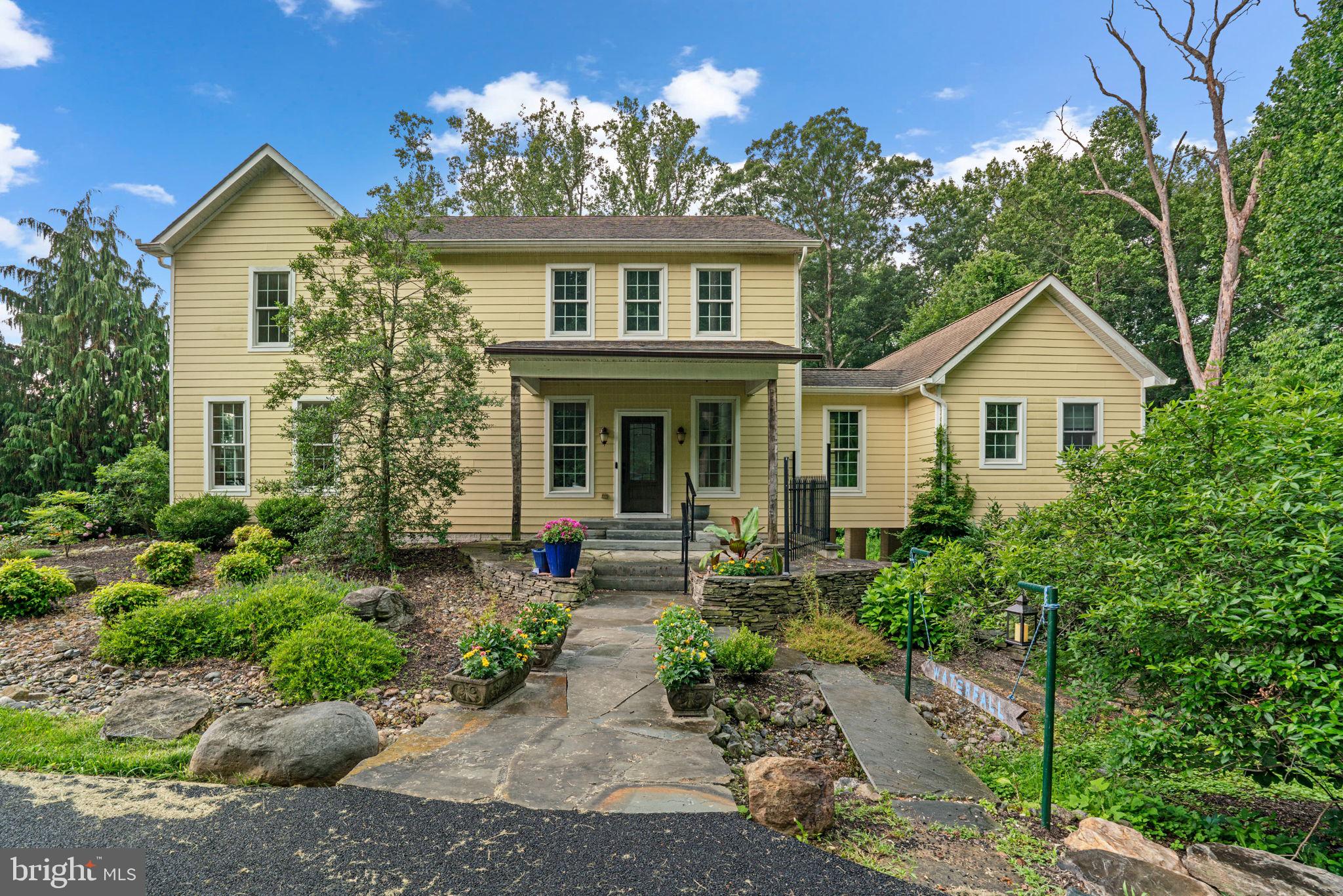 Nature lover's paradise in My Lady's Manor! This one-of-a-kind 4-bedroom home blends natural beauty with elegant design and is perfectly positioned near the NCR Trail, offering easy access to miles of scenic walking, biking, and horseback riding through wooded landscapes, streams, and open fields.
A charming stone path and stone wall lead to the welcoming front porch. Inside, the open-concept main level features a stunning two-story cathedral ceiling that floods the kitchen and dining room with natural light. The beautifully designed kitchen boasts marble countertops, glass-front cabinetry, a detailed tile backsplash, and stainless steel appliances, including a gas range. The dining room opens through a French door to a spectacular bi-level bluestone patio—partially covered—perfect for outdoor dining and peaceful nature views.
The cozy family room features a floor-to-ceiling stone hearth fireplace, and hardwood floors flow throughout most of the main level. Tucked away for privacy, the first-floor owner's suite is entered through French doors and includes a private deck overlooking the woods and a spa-like ensuite bath with dual sinks, a luxurious air bubble soaking tub, and a large river-rock floor shower with dual showerheads.
The main level also offers a home office, convenient half bath, and a laundry room. Upstairs, you'll find three additional bedrooms and a full hall bath. One bedroom includes its own private full bath, making it a great option for a second owner's suite or guest quarters. An open hallway overlooks the bright kitchen and dining area below, adding to the home's unique architectural charm.
The property is beautifully landscaped and hardscaped, blending seamlessly with its peaceful wooded surroundings. A garage permit has been secured, and the foundation floor is complete—ready for the next owner to add doors, walls, and a roof to finish the space to their needs.
With a horse barn within view and quick access to the NCR Trail, this home offers the perfect balance of privacy, natural beauty, and convenience in a truly special setting.
