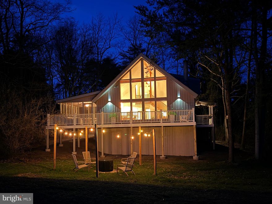 393 Tecumseh Trail is a striking A-frame retreat set within The Woods, perfectly positioned along the 2nd hole of the Mountain View Golf Course—where the architecture, light, and the setting effortlessly come together. Equally compelling as a short-term rental, weekend getaway or primary residence, this property offers proven performance and strong guest appeal. 

From the moment you enter, the home makes a statement. Brand new midcentury lighting throughout + a brand new fiberglass and glass entry door add to the dramatic wall of windows; the soaring cathedral ceilings; and the glow of the warm hardwood flooring. This is a bright, elevated living space that feels both expansive + rich. The wood-burning fireplace anchors the room with classic chalet character and year-round appeal.

The kitchen has been thoughtfully updated with quartz countertops, stainless steel appliances, and clean-lined cabinetry—functional, modern + seamlessly integrated into the open floor plan.  A newer stacked washer and dryer fit snugly in the closet beneath the staircase.

The outdoor living is a standout. A screened porch provides a quiet, private retreat, while the TimberTech deck spans the rear of the home, overlooking the fairway and surrounding natural landscape. The setting is peaceful, private, + highly marketable!

Both bathrooms have been refreshed with modern vanities, quartz surfaces, and updated fixtures, delivering a cohesive, move-in-ready experience.  Additional features include parking for 4+ vehicles and an approximately 500 sq ft high-ceiling storage area beneath the home—ideal for owner storage, supplies, or future value-add potential.

Whether used as a primary residence, weekend escape, or investment property, this home delivers the lifestyle buyers seek in The Woods—design, setting, and flexibility.

As a short-term rental, the property has a proven track record of generating approximately $25K annually when not owner-occupied, offering immediate income potential with room to grow.

The layout aligns with what guests consistently book: open-concept living with vaulted ceilings; floor-to-ceiling windows (key booking driver) wood-burning fireplace for year-round demand; an updated kitchen with quartz  + stainless... set against golf course frontage + scenic views.

Further upside exists for the next owner through operational optimization and strategic upgrades—such as adding a hot tub; enhancing outdoor living; or finishing the walk-out lower-level storage area into a game or recreation space to increase nightly rates and occupancy. 

The current owner inspected and made tons of upgrades and provided the love and care needed to address maintenance concerns including replacing 12 6X6 posts supporting the deck.  Inspection + a list of repairs available.  This home has an active B membership (pools + gym) to the Woods Club.