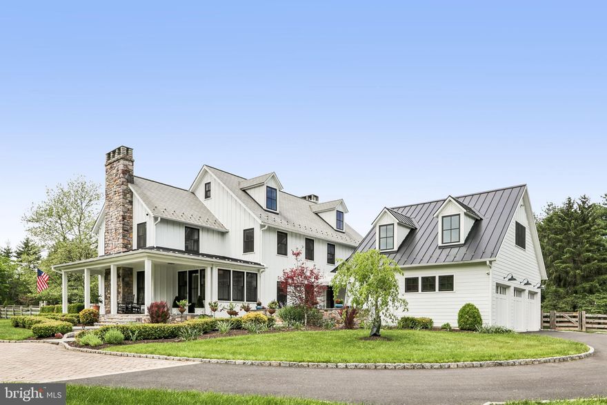 Originally crafted by Worthington Homes and magnificently reimagined for today’s luxury lifestyle, this extraordinary modern farmhouse colonial is gracefully set on 3 pristine acres within Upper Makefield’s  Windy Hollow community. Offering 4 bedrooms, 4 full & 2 half baths, the completely remodeled residence showcases a seamless blend of timeless architecture, sophisticated design & uncompromising quality. From the moment you arrive, the home makes a striking impression. Newly installed Hardie Board siding, new roof, all new windows & doors, along with a newly added bluestone front porch, courtyard & walkway, create a stately yet welcoming presence, while the beautifully manicured grounds enhance the property’s estate-like setting. Step inside the redesigned entrance addition where warmth, elegance & craftsmanship immediately unfold. Rich hardwood flooring spans all three levels, complemented by recessed lighting, custom window treatments & refined architectural details throughout. The formal living room offers an intimate gathering space with a fireplace & custom moldings, while the elegant dining room is adorned with crown molding, wainscoting, built-in cabinets & direct courtyard access for effortless indoor-outdoor entertaining. Nearby, the richly appointed study features custom built-ins & detailed millwork. A beautifully renovated powder room completes this wing of the home. At the heart of the home is the spectacular great room highlighted by a coffered ceiling, fireplace & wet bar with beverage refrigerator—ideal for both grand entertaining & relaxed everyday living. The reimagined state-of-the-art chef’s kitchen is simply stunning with custom white cabinetry, designer gold hardware, exotic stone countertops & a dramatic double-thickness center island. Luxury appointments include pendant lighting, a custom wood hood, pot filler, wine & beverage refrigeration & professional-grade stainless appliances including a built-in refrigerator, double ovens with steam, drawer microwave, range-top with 4 gas burners, 2-zone induction, sous vide & dishwasher. Adjacent is an exceptional pantry room lined with extensive cabinetry & an additional renovated powder room. A private staircase leads to a separate suite complete with an updated full bath—ideal for guests, au pair, extended family—while access to the immaculate 3-car garage with epoxy flooring, storage, EV charger, utility sink & bike lift is conveniently nearby. Upstairs, two secondary bedrooms each enjoy beautifully updated en-suite baths. The thoughtfully designed laundry room features custom cabinetry, quartz countertops, oversized sink, tile flooring & washer and dryer elevated on pedestals. The magnificent primary suite serves as a luxurious private retreat with fireplace & custom beverage center. An extraordinary dressing closet includes extensive built-ins & a center chest with stone countertop. The spa-inspired primary bath features dual oversized vanities, extensive storage, an oversized curb-less shower with dual shower heads & body sprays, soaking tub, heated floors & private water closet. The added third-floor space offers a versatile lounge area plus substantial unfinished space already suited for expansion into two additional bedrooms & another full bath. The finished lower level provides exceptional recreation space highlighted by a temperature-controlled 246-bottle wine cellar. Outside, a wraparound deck overlooks the fenced rear yard framed by mature professional landscaping. New paver walkways connect the home’s outdoor spaces, while a whole-house generator & two new HVAC systems provide peace of mind. A large storage building with shed dormer adds both character & functionality. Every inch of this exceptional residence has been thoughtfully renovated with the finest finishes & craftsmanship. Ideally located near major highways, trains, parks, shopping & everyday conveniences, all within the award-winning Council Rock North School District