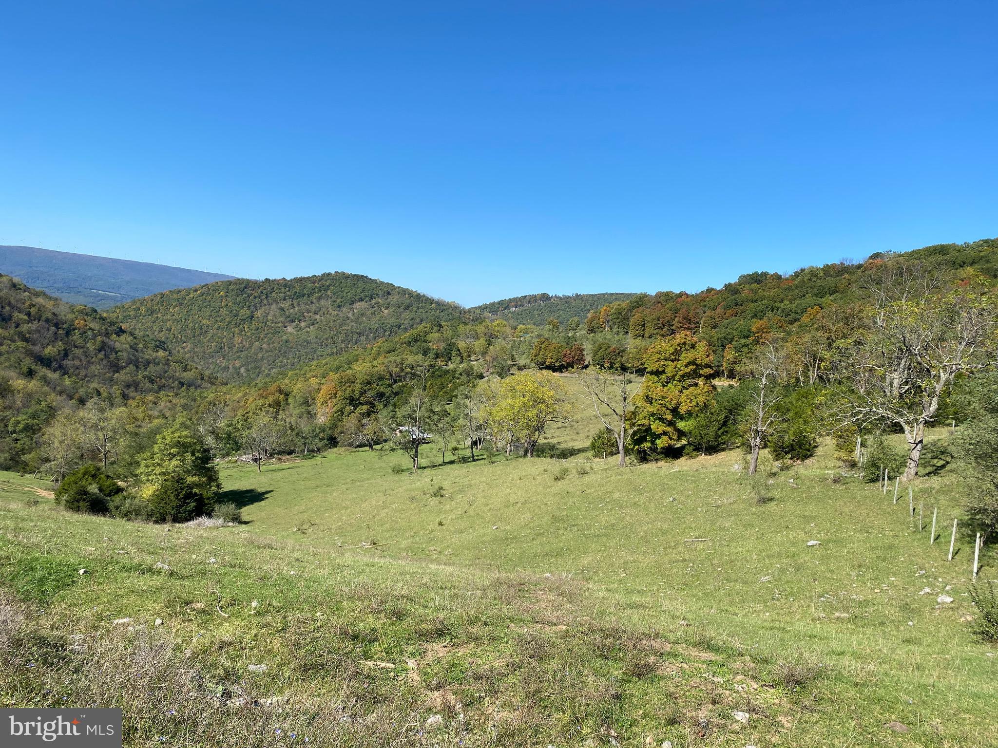 Located atop Patterson Creek Mountain, this old mountain top farm of rolling fields and woodland, with views to the Alleghenies to the west and South Branch Mountain to the east, is truly one of the most picturesque areas around. Fenced and partially cross-fenced and presently leased for pasture, it has an old house on it that is most likely past restoration. It has a decent spring or two, a small stream and the ridge top would be perfect for a windmill to generate your power! If off-grid homesteading is what you're searching for, this is the one! Located in Grant county on the Hardy/Grant County line, it is unrestricted and the possibilities are endless for what you could do here. Within a half hour of river access/shopping/medical in progressive Moorefield, and an hour to Davis for skiing and outdoor recreation, this location is perfectly situated on a low-traffic county road with lots of privacy! There is even an old quarry on the property for your convenience to build interior roads. A right of way has been obtained for electric. Views for miles from numerous building sites make this an entrepreneur's dream for building tiny house off-grid rentals, etc. Also perfect for the local farmer looking for more pasture (approximately 200 acres), as you know how hard THAT is to come by! Locked gate - must be accompanied by agent. Selling "AS IS"