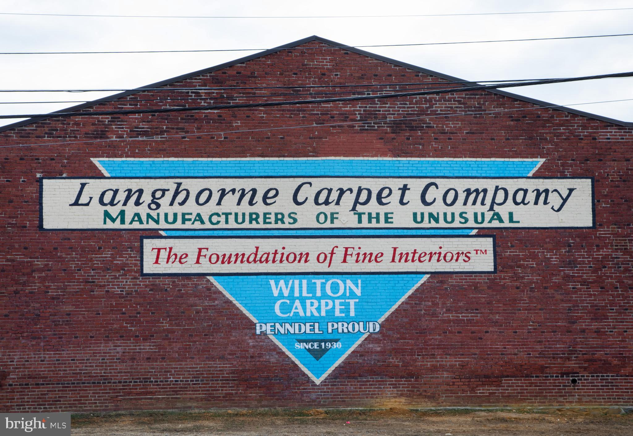 The Langhorne Carpet Company, producers of fine Wilton loom carpeting since 1930, is available for the first time in generations. The longest continually operated mill in the United States, every one of its carpets is made on site in a sprawling +/- 50,0000 SF red brick building on over 4 acres in Penndel Borough, Bucks County, PA. Most production is on the original mechanical looms sourced from Henry Ford. This company’s dedication to superior craftsmanship and unparalleled raw materials (the finest wool from Britain and New Zealand) has propelled this business to national prominence, and its products can be found in such iconic landmarks as the White House, American Embassies abroad, the Henry Ford Estate, historic houses of worship, and has served notable clients such as Pope Francis. From classic to contemporary, the business stocks several running lines, excels at custom design, and can reproduce any heritage carpet. Frequent collaboration with decorator and design firms, custom material blends can include Peruvian Alpaca or silk blended into the wool, creating 100% natural products without synthetics. Ideally located on the periphery of Philadelphia and close major shipping infrastructure and ample labor force, this is a rare opportunity to take the reigns and continue a business that stands out as truly and “one of one”. Contact the listing broker for details, do not enter the property without a scheduled appointment with the broker and do not approach the employees.