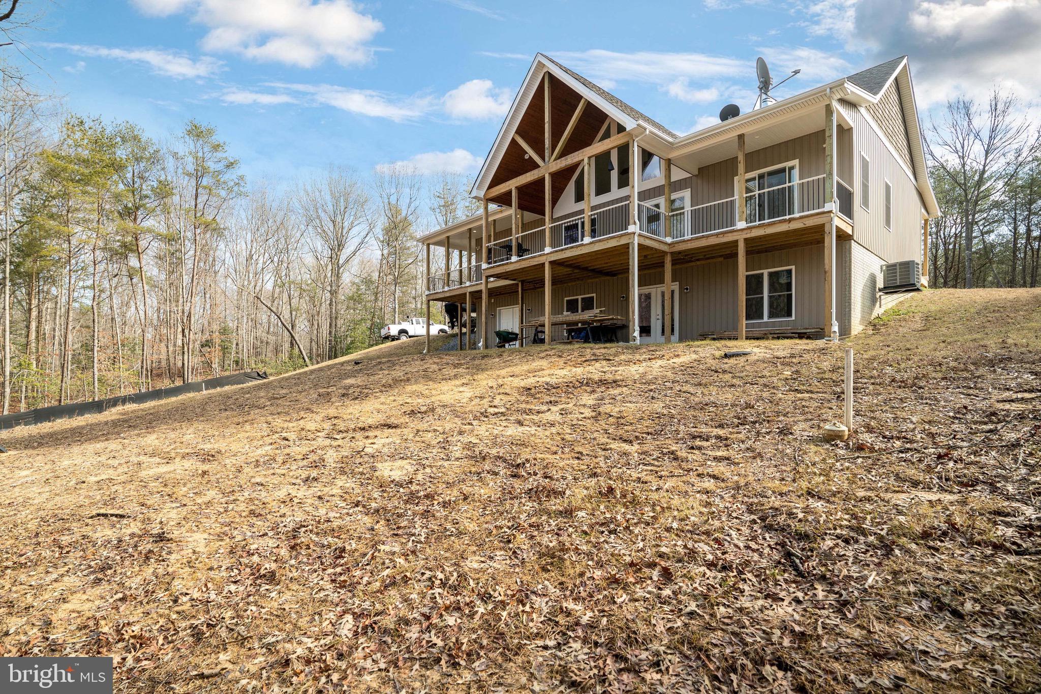 This completely custom built in 2020 home is nestled in 14 acres of private wooded land. Vaulted ceilings, with 100 year old barn wood exposed beam detail. A cozy fireplace compliments the stunning natural hickory floors through out. Enjoy the gorgeous wrap around porch with 1100 sq ft of deck space with cedar plank deck ceiling with recessed light, perfect for entertaining or just taking in the peaceful wooded views. Upper level has 3 bedrooms, 2 bathrooms. Master bathroom sports a luxurious walk in shower with overhead rain shower head, and soaking tub. Walkout basement with French doors is unfinished but roughed in for a bathroom, a blank slate for whatever you can imagine. No expense was spared in this build, it is a must see!! ****Please do not attempt to drive by/ look at property without an agent and confirmed showing*****
