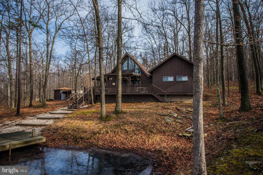 Nice looking home with large garage/workshop for home business or hobbies.  Original home was chalet style, addition adds bedroom and living space on the main level. Newer pellet stove included plus shed outside, covered wood storage, masonry outdoor fireplace, fire pit, pond. All on 10.86 private acres (2 lots).  Motivated seller!