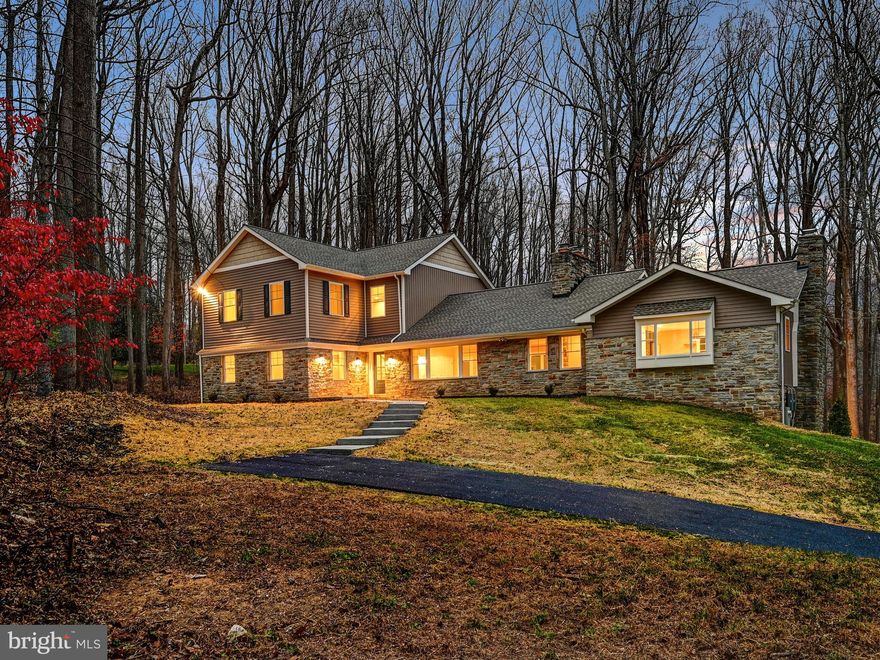Beautifully reimagined and redesigned, this fully renovated 6-bedroom home is nestled in a quiet arbored corridor of Manor road. Sited atop a hill on 3.67 acres of woods, the home offers tranquility and privacy. Upon entering, the great room graciously welcomes you with a stone fireplace and hearth setting the tone for this exquisite home.  The well-appointed modern kitchen awaits you and is ready to host your friends and family, meeting each of your entertaining needs. Large picture windows flood the kitchen with natural sunlight. A separate galley wet bar is perfect for both holiday parties and casual entertaining. Cross through the vaulted foyer to your home office and first-floor primary suite with en-suite bathroom, complete with separate laundry and a walk-in closet. A large upstairs offers 4 bedrooms, bathrooms, and another laundry room. The lower level offers an expansive great room, fireplace, garage access, and separate in-law suite. Modern Luxury for the modern family awaits you here. This is THE ONE for you.