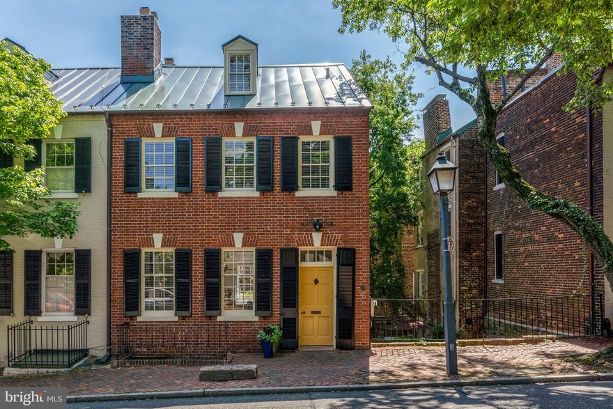 Located in the heart of Old Town, Alexandria, this semi-detached, brick townhome is elegant, spacious and fully updated. The separate entry foyer welcomes you with exquisite arched mouldings, original hardwood floors and high ceilings. Both the stately living and dining rooms feature a wood-burning fireplace. A gorgeous Dutch door leads the way to an elevated terrace overlooking a private, fully fenced, back garden and patio.  The kitchen and family room, with an additional wood-burning fireplace, are centrally located and offer access to a side patio, back garden and covered patio. These multiple outdoor spaces allow for alfresco dining, entertaining and private enjoyment. A grand staircase leads the way to two spacious bedrooms, each with a fireplace, and an exquisite primary bath. The top-level houses two additional rooms and a renovated full bath. Recent improvements include a new roof, modernized baths, refinished hardwood floors, interior and exterior painting, restored chimneys, relined fireplaces, designer lighting and much more. This exceptional home is flooded with natural light, is in pristine move-in condition and in a premier location just steps to shops, restaurants, parks and the waterfront.