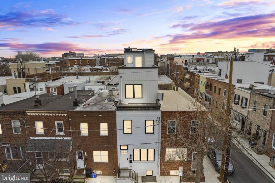 Discover life in East Passyunk, Philadelphia’s most vibrant neighborhood, renowned for its exceptional food and drink scene. Connected to the Avenue on a charming tree-lined street, this newly renovated townhome offers modern luxury in a prime location. Benefit from a 10-YEAR TAX ABATEMENT  while enjoying this beautifully updated residence. The exterior features a freshly painted white brick facade. Step inside to find exposed brick and gleaming hardwood floors that flow seamlessly through the open floor plan encompassing the living, dining, and kitchen areas. The kitchen is a chef’s dream, boasting quartz countertops, a tiled backsplash, sleek wooden cabinets with gold handles, and carefully selected all white appliances. A convenient powder room is located on the main floor, and the kitchen opens directly to a fenced-in yard, perfect for barbecues and entertaining. Upstairs on the second floor, you’ll find two bedrooms with ample closet space and a full bathroom. The hallway bathroom features a fully tiled bathtub/shower, an all white vanity sink, and high-end golden fixtures. The 3rd floor hosts the bright and airy primary suite equipped with high ceilings, stylish white wall paneling, and a luxurious ensuite bathroom equipped with golden fixtures, a spacious shower area, and floor-to-ceiling tiles. The fully tiled finished basement can serve as an extra bedroom or creative space and also provides laundry room and extra storage areas. One of the home’s standout features is the expansive roof deck, offering uninterrupted views of the Philadelphia skyline. You’ll be within walking distance of numerous popular restaurants and pubs, including Flannel, Cantina Los Caballito's, Stogie Joes, Barcelona Wine Bar, Bing Bing Dim Sum, South Philadelphia Tap Room, and so much more! Come and make this exquisite renovation in East Passyunk your new home.