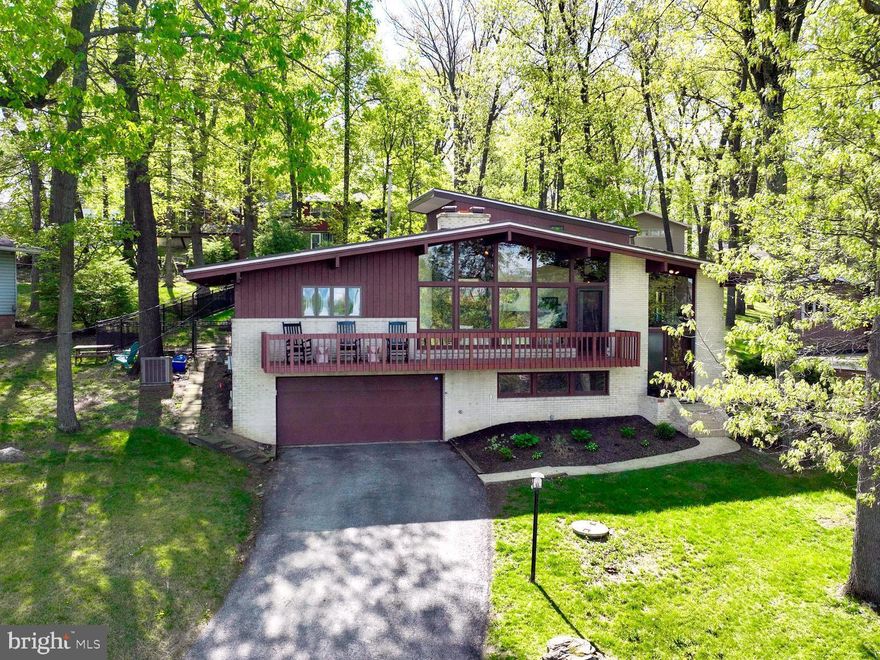 WOW! Check out this unique mid-century modern in York Suburban School District. This home is move in ready and boasts a bright and open layout with cathedral ceilings throughout. The heart of the home is the living room. This cozy space offers a floor-to-ceiling fireplace with a fabulous view off of the private balcony. The living room flows seamlessly into the kitchen and dining area - making entertaining a breeze. Directly off of the kitchen is the sunroom with access to the private, fenced in backyard. Conveniently, three of the four bedrooms are located on the main floor. The primary suite offers a private en-suite bathroom and direct access to the patio. A full, remodeled guest bathroom with a double vanity completes the main floor layout. The upper level can be accessed by the spiral staircase and can be utilized as a fourth bedroom. This room offers a walk-in closet, half bath, and a private balcony. The lower level is perfect for extra living or entertaining space. The finished family room offers a gas fireplace and half bath/laundry area. Enjoy the large custom paver patio perfect for your summer BBQ’s & entertaining! Just minutes to York Hospital, York College, Apple Hill Medical Center, York Country Day School, and the York County Heritage Rail Trail.