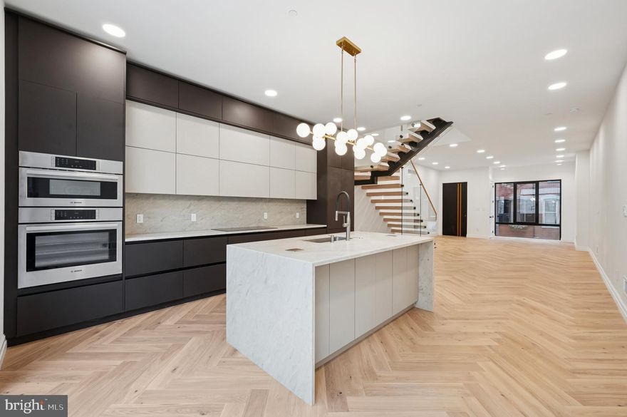 Approved 10 Year tax abatement! Step into this beautifully designed home where every inch is crafted with care and attention to detail. Inside you'll discover herringbone-patterned white oak flooring that exudes timeless elegance. The open-concept living area is adorned with a floating staircase featuring solid 4-inch oak treads and sleek glass railings, creating a striking architectural centerpiece. European tilt-and-turn aluminum windows by Reynaers flood the space with natural light while ensuring energy efficiency and sound insulation. The gourmet kitchen is a chef's dream, equipped with built-in Bosch appliances, 10-foot custom cabinetry, and waterfall-edge countertops that provide both functionality and aesthetic appeal. Offering three (3) spacious bedrooms and four (4) elegant bathrooms, this home is the perfect blend of style and functionality. The finished basement provides even more space, ideal for a guest room (4th bedroom), home office, or playroom, a true bonus. Each bedroom includes built-in closets, ensuring ample storage and organization. The master suite is a sanctuary of luxury, featuring soaring 10-foot ceilings, a state-of-the-art walk-in closet illuminated by integrated LED lighting, and a spa-inspired bathroom. The master bath offers a peaceful retreat, complete with a curbless shower, premium Isenberg polished nickel faucets, and an innovative speaker exhaust fan, elevating both functionality and relaxation. 8-foot solid core doors throughout the home underscore its quiet elegance and superior craftsmanship. Multi zoned 2 central HVAC systems, 4 zones through out the house - home is divided into four (4) distinct areas, each with its own thermostat and independent temperature control, connected to two (2) separate central heating and cooling units. Enjoy sweeping panoramic views of the city skyline from the tiled rooftop terrace - an ideal setting for both quiet relaxation and stylish entertaining. The cedar-fenced backyard offers a serene outdoor escape, blending privacy with natural charm. Complementary 1 year paid parking at the nearby garage rental.  Nestled on a peaceful, picturesque street rich with history, this residence offers a rare sense of tranquility while remaining just moments from the vibrant energy and convenience of city life, truly the best of both worlds. Located in one of the city's most sought-after and walkable neighborhoods, the home is surrounded by beautifully preserved historic residences that lend timeless character and charm to the area. The block feels exceptionally private and quiet, yet you’re just a short stroll to Trader Joe’s, Giant, river trails, parks, shops, and cozy neighborhood cafes. Here, walkable urban living meets classic elegance and a strong sense of community.