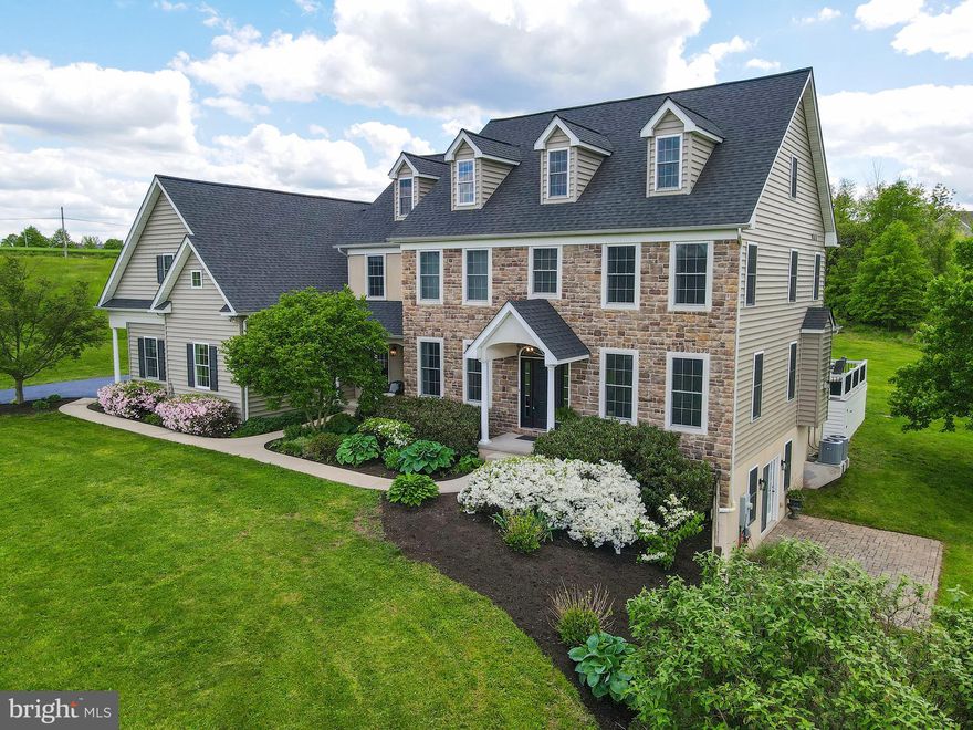 Welcome to this custom-built Farmhouse Colonial with a 3-car side entry garage, nestled on 2.46 picturesque acres, boasting a full In-Law suite with private entrances. A meandering walkway guides you from the extra-long newly paved driveway to the welcoming front Portico entrance. Step inside to discover an inviting entry Foyer adorned with random plank hardwood flooring and a gracefully turned wood staircase ascending to the Upper Level. Frosted glass French doors unveil the Craft room/Office, complete with ¾” random plank hardwood floors and dual built-in shelves flanking the exit door to the Family Room. The formal Dining Room exudes elegance with its random plank hardwood flooring, adorned with crown and dental moldings, complemented by two candlelight wall sconces. An epicurean's delite, the gourmet Kitchen is a haven for culinary enthusiasts. Featuring random plank hardwood flooring, granite counters showcasing an undermount farm-style stainless steel sink, and a wraparound butler’s pantry equipped with additional cabinetry, shelving, sink, and a convenient beverage refrigerator. Upscale stainless-steel appliances include a DCS 5- burner cook-top with a Broan Elite vent hood, a Kitchen Aid double wall oven and separate microwave, a Whirlpool dishwasher, and a French door refrigerator.  Revel in the functionality of the generous center Island, adorned with granite counters, seating, cherry cabinetry, and shelving. The adjacent breakfast room seamlessly expands the kitchen space, while French doors open onto a sprawling covered maintenance-free deck and a spacious paver patio with a firepit. Unwind or host guests in the sun-drenched Family Room, highlighted by a stone front gas-burning fireplace adorned with a raised slate hearth, a wood mantle, and complemented by built-in wall shelving. Enjoy the ambiance enhanced by recessed lighting. Transitioning from the Family Room, step into a hallway leading to the main floor Laundry Room, complete with a sink, cabinetry, and ceramic tile flooring. Additionally, this spacious hall area features a convenient Half Bath and an extra front egress door. Enter the full In-Law Suite through a sliding barn door, unveiling a spacious Living Area adorned with two sets of built-in shelving. The accompanying kitchen boasts maple cabinetry and includes a Kenmore refrigerator, complemented by random oak hardwood flooring. This private enclave also offers a separate entrance for added convenience. Additionally, discover a private Bedroom featuring dual walk-in closets, alongside a full Bath equipped with a tub/shower and a linen closet. A private door provides direct access to the deck and patio areas.  Back inside, ascend to the Upper Level, where double doors unveil the lavish Owner’s Suite. This luxurious space features plush carpeting, enhanced by recessed lighting and a cozy sitting area. The Owner’s Bath is a sanctuary of relaxation, boasting a Jacuzzi air jetted tub, dual separate vanities, a tub/shower, and a room-size walk-in closet. A separate commode area offers added privacy. Also on this level are three beautifully appointed Bedrooms, accompanied by a Hall Bath featuring a tub/shower. Additionally, an expansive Bonus/Recreational Space awaits, complete with a spacious semi-finished closet that holds potential for conversion into an office space. From the hallway, stairs ascend to a vast floored attic, offering the possibility for future finishing. Moreover, the appeal of this location is enhanced by it's close proximity to the Indian Valley Country Club, providing residents with convenient access to upscale amenities and recreational activities. This well-positioned residence boasts additional luxuries, a separate au-pair/in-law suite and much more!