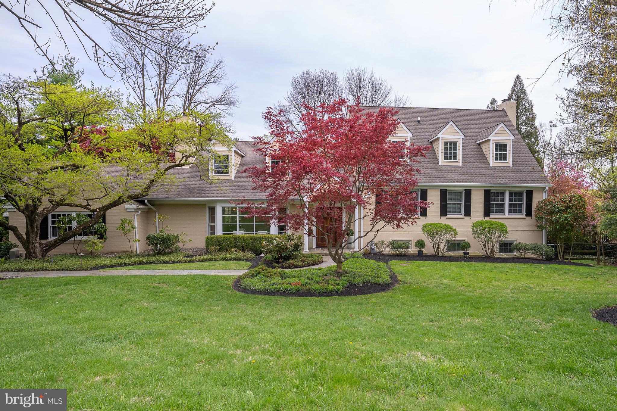 Tucked away on a quiet Gladwyne cul-de-sac neighboring Philadelphia Country Club, 1717 Martins Lane is a thoughtfully modernized painted brick farmhouse offering a seamless blend of timeless design and contemporary comfort. Set on beautifully landscaped grounds, the home’s wide terraces and sparkling pool invite outdoor living and entertaining in a private, resort-like setting.
Inside, richly stained hardwood floors unify the open, sun-filled layout. A deep bay window illuminates the formal fireside living room, which flows effortlessly into the dining area and onward to a striking kitchen designed for both everyday use and hosting. Outfitted with stainless Thermador appliances—including French door refrigeration and 6-burner gas range—the kitchen features a large L-shaped seated island, deep white farm sink, and expansive single-pane window that fills the space with natural light.
The adjacent family room, anchored by a crisp white brick gas fireplace, is flanked by custom built-ins that offer stylish and efficient storage. Just a few steps up, three bedrooms include one en suite and two that share a double-vanity hall bath.
The private primary suite is a true retreat, accessed behind double doors and offering abundant natural light, generous closet space, and a luxurious bath with white stone-topped double vanity, deep soaking tub, and seamless glass-enclosed dual shower.
The top level is perfect for guests, work, or play, with two large bedrooms—one currently used as an office—and a spacious lounge or den. A full hall bath serves this floor, offering flexibility for a variety of needs.
On the lower level, a home gym, recreation space, and lounge area with a repurposed brick fireplace extend the living space. A large unfinished storage room with workshop, dedicated laundry with sink, and a convenient powder room round out this level, with direct access to the rear garden, sweeping terrace, and pool with integrated hot tub.
1717 Martins Lane offers a rare opportunity for turnkey living in one of Gladwyne’s most desirable locations.