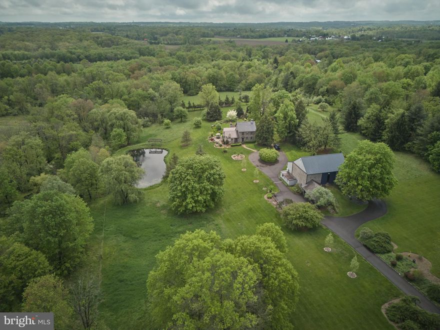 Privately located along picturesque Sweetbriar Road lies Drumbore Farm, a remarkable historic estate that blends the elegance of the past with the comforts of the present. With origins tracing back to the late 1600s — on land once granted to William Penn — this property at 71 Sweetbriar Road is a true time capsule, carefully preserved and thoughtfully updated over the course of more than 300 years.

Set on 10 serene acres and enrolled in Pennsylvania’s Act 319 program, Drumbore Farm offers not only breathtaking views but also a significant tax incentive for those committed to stewarding this exceptional land.

Upon arrival, guests are greeted by a striking historic bank barn that reflects both authenticity and modern functionality. Original stanchions and horse stalls remain intact, preserving the barn’s agricultural heritage, while recent enhancements — including a new roof and exposed interior stonework — add to its lasting charm. The first floor includes garage bays for four vehicles, a greenhouse, and generous storage space. The second floor unfolds into a grand central hall ideal for entertaining, flanked by a kitchenette, dining area, and a comfortable lounge. Tucked into a rear corner is a temperature-controlled studio space, currently used for recording and painting.

The main residence features four well-appointed bedrooms, including a spacious primary suite on the first floor with a private bath, wood burning fireplace, beamed cathedral ceiling, and in-suite laundry. Two additional bedrooms and a full bath are located on the second level, while the third floor is home to the whimsical “Princess Suite” — a cherished and character-filled retreat. A third full bath is conveniently located on the main floor. Radiant floor heating in two of the bathrooms and throughout several rooms enhances comfort year-round.  Every corner of the home has been completed with thoughtful intention and profound dedication to creating a warm, inviting space.

In 2018, a meticulously designed chef’s kitchen was added to the home. One side of the kitchen features custom, floor-to-ceiling cabinetry with internal lighting, natural wood flooring, and reclaimed ceiling beams — creating a rustic yet refined atmosphere. The kitchen is completed with a large, soapstone topped custom center island abound with thoughtful storage, a magnificent Wolf stove and double oven, and open counter space overlooking the scenic yard. This culinary space offers both beauty and functionality, making it the heart of the home.

Outdoors, the grounds are a paradise for garden enthusiasts. A lush landscape of vegetable, fruit, and flower gardens flourishes behind the house, while a tranquil pond invites quiet reflection. Tucked alongside the barn, under the shade of a grand maple tree is a bluestone patio, complete with comfortable seating and a custom pizza oven. Every corner of the property is designed to inspire a connection with nature and heritage.

Located within the serene embrace of Bedminster Township, this distinguished estate offers a rare sanctuary of privacy without the sacrifice of accessibility. Drumbore Farm lies among the vibrant communities of Bucks County and is within comfortable reach to Philadelphia, New Jersey, and New York. 

Featured in Bucks County Magazine and on several house and garden tours, Drumbore Farm is not merely a home — it is a rare opportunity to own a living piece of history. Don’t miss your chance to carry this legacy into the future.