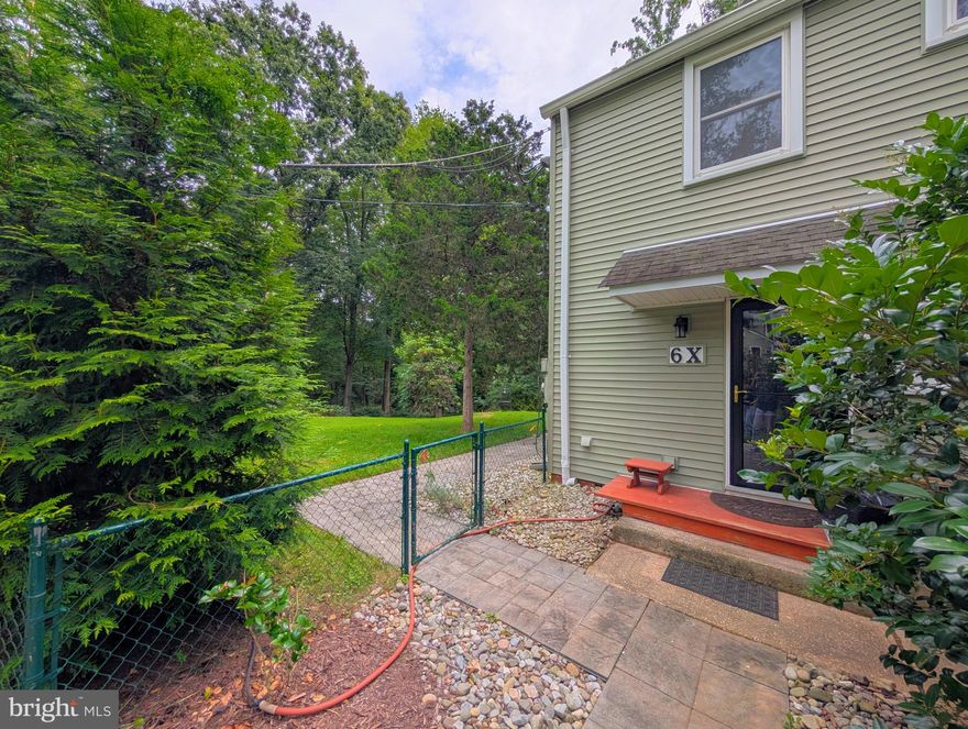 LARGE, FENCED CORNER LOT - One of the largest yards in Greenbelt! The stone walkway follows around the side of the home to the large concrete patio for entertaining.  The owner is including the wrought-iron dining table and chairs, along with a fire pit, wind chime, storage cabinet and umbrella.  There's also multiple bird baths and feeders throughout the yard.  A stone stairway leads through the garden trellis and into the lower yard.  The wooden pergola is included, along with the wood deck with spacious storage shed. The back gate opens onto more than 100 acres of protected woodlands; enjoy birds, deer and other wildlife. On the interior main level you'll find a separate laundry room with full-sized washer and dryer. The kitchen has been remodeled with bright cabinets (the protective layer is still in place!) along with a modern stove, microwave and dishwasher.  The sunlit living room has lots of windows and refinished Oak hardwood flooring. Upstairs, the ceramic-tiled bath upstairs has modern fixtures.  Both bedrooms have windows on 2 sides and refinished Oak hardwood flooring.  The full-sized attic has lots of storage space for all of your extras.  The energy-efficient mini-split HVAC system provides QUIET heating and cooling for year-round comfort.  Modern thermal-pane windows and insulated front & back doors have been recently installed. A reserved parking space included, along with plenty of visitor parking.  The city sidewalk network leads to Roosevelt Center - groceries, theater, aquatic & community centers, restaurants, salons, bakery, banking & more.  Enjoy Greenbelt Lake, Buddy Attick Park, tennis courts, ballfields, playgrounds and lots of other recreational opportunities. Total of $736.20 includes all TAXES, insurance, trash pickup, renovation program, replacement reserves & most structural maintenance. (walls, roof, wiring, plumbing, hot water heater & more.)