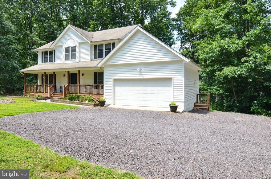 Welcome to country living at its best in King George! This colonial beauty is over 3500 finished square feet on 12 acres surrounded by majestic oaks, maples, and wisteria.  Plenty of parking space for your cars in the 2 car attached garage or 2 car detached garage. There is also a concrete pad for your boat by the detached garage that has electricity and running water. Who doesn't love a full covered front porch to sit and observe nature while relaxing with your favorite cup of java or chai latte? Come on in! Notice the gleaming oak wood floors that lead to a spacious gourmet kitchen with quartz countertops and a gas stove that even a novice chef can appreciate. The sprawling family room offers a wood fireplace to warm up your soul on chilly evenings. Out on the deck, you will find a jacuzzi for hydrotherapy or for pleasure. Another nice feature on this property is a welcoming above ground pool for those scorching days of summer. There are 3 good size bedrooms upstairs. The master bedroom offers an added sitting room. The basement is fully finished with a recreation room, bar area, and exercise room. There are 2 additional rooms that can be used as bedrooms NTC or storage rooms. No worries about bad storms, there is a house generator. This property is in an ideal commuting location to NSWC Dahlgren which is approximately 8 miles straight shot to the main gate. NO HOA. Road maintenance is $225.00 every 6 months.