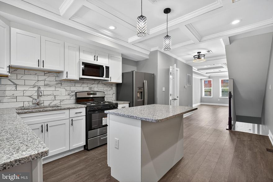 Welcome to this meticulously reimagined 4-bedroom, 3.5-bathroom townhouse, where historic Baltimore charm meets contemporary luxury. Every inch of this home has been thoughtfully updated to provide a sophisticated living experience. Sophisticated Main Level, step inside to an expansive open-concept floor plan characterized by soaring coffered ceilings and recessed lighting. The striking exposed brick wall spans the length of the main level, adding warmth and texture to the modern aesthetic. New wide-plank flooring guides you through the light-filled living area into a true chef’s kitchen. Sleek white shaker cabinetry paired with elegant granite countertops. A full suite of stainless steel appliances, including a gas range and built-in microwave. A center island with breakfast bar seating, classic subway tile backsplash with marble-style accents, and contemporary pendant lighting. The upper levels house spacious, sun-drenched bedrooms with plush new carpeting and ample closet space. Each of the 3.5 bathrooms has been transformed with high-end materials:
Custom marble-patterned floor-to-ceiling tiling in the showers. Modern vanities with brushed nickel fixtures. A convenient main-floor powder room for guests. The fully finished basement offers additional living space—perfect for a fourth bedroom, home office, or media room—and includes a full bath for maximum flexibility. Exposed brick, coffered ceilings, and custom trim work throughout. New HVAC and energy-efficient windows for year-round comfort.
Conveniently located with easy access to commuter routes and downtown Baltimore amenities.
Schedule your private tour today and experience this masterfully renovated home for yourself!