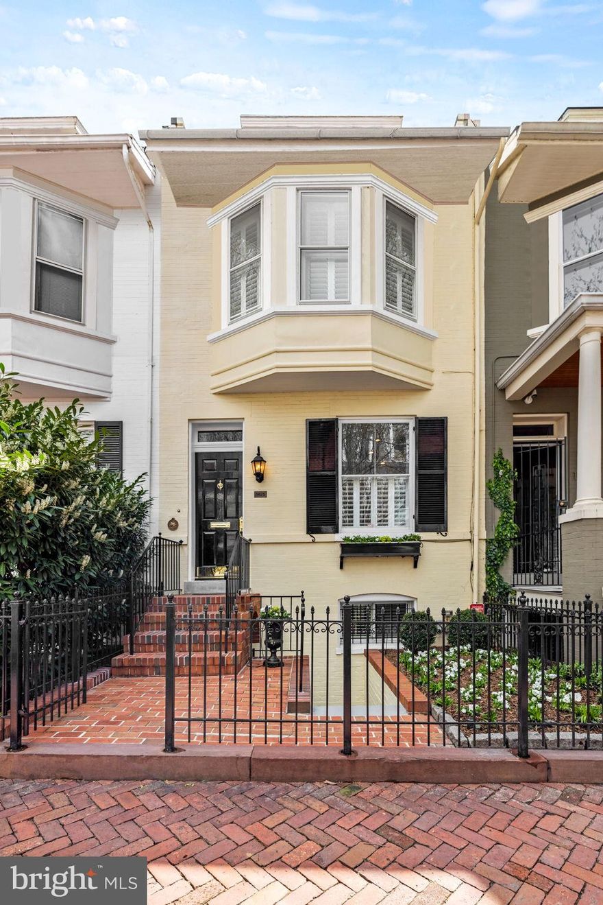 Nestled in the heart of Georgetown's picturesque West Village, this beautifully updated townhome exudes timeless elegance and contemporary luxury. With its seamless blend of historic details and modern upgrades and amenities, this home provides the ideal oasis for sophisticated Georgetown living. Just a short stroll to Wisconsin Avenue, 1425 33rd Street sits between two cobblestoned streets and offers the prized and rare convenience of a separate two-car garage, eliminating the need to find parking in Georgetown. 

As you step through the gated entrance, a welcoming landscaped front garden greets you. Step inside through the inviting foyer leading into spacious and light-filled living room, where high ceilings, custom mantel and moulding, architecturally lit bookcases, plantation shutters and a new gas fireplace create an atmosphere of understated elegance. Features throughout the Main Level include oak flooring and recessed cove lighting, providing the home with a rich, finished quality. The adjacent Dining Room, also with custom moulding and elegant light fixtures, offers ample space for entertaining and dinner parties. The updated kitchen, with custom cabinetry, marble countertops, and top-of-the-line Viking, SubZero and Miele appliances and under counter separate Uline ice-maker, caters to any cooking style. The main level also includes a large hall closet with California Closet built-ins and a spacious powder room with a linen closet. The ideal convenient unified floor plan is completed by a separate eat-in space that opens onto a private slate patio leading to the separate garage and with beautiful fully grown shrubbery and custom Brazilian wood accent fencing, a tranquil retreat in the heart of the city. The exquisite attention to detail and finishes on the Main Level - in harmony with and enhancing the historic character of the home - can be found throughout the home on each floor. 

Up the skylighted stairs, the Primary Suite beckons with its light-filled ambiance, high ceiling and fan and charming bay window seat with storage. Custom-built closets provide ample storage space, while the en suite Primary Bath features another large skylight, double vanity, separate water closet, separate linen closet and heated floors for added comfort. The second level also offers versatile office space, featuring a custom built-in desk and spacious custom closets. An additional bedroom next to another full bath is adorned with a custom California Closet and ceiling fan, affording privacy and convenience for guests or family members. 

The Lower Level offers even more space for entertaining and relaxation and includes a large den featuring custom mantel, built-ins and millwork and new gas fireplace, and as well as custom wet bar with copper sink and cove lighting. A Full Bath with steam shower and a third bedroom with ample closet space complete the level. The Lower Level also offers both front and rear access to the home.  

In addition to the separate two-car garage, other features include a historic slate roof facade, attic storage space, extensive Stark carpeting, full access to WiFi and cable throughout, front and rear patio watering systems, landscape lighting and more.