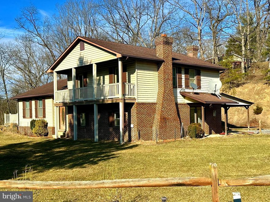 This tri-story residence located in Hardy County, WV is situated on an elevated  & level lot.   The kitchen showcases honey-toned cabinetry, stainless steel appliances, and upgraded solid surface countertops. A huge oversized deck just off the main living area is ready to be enjoyed as warmer temperatures arrive.  The home boasts 3 bedrooms and 2 full bathrooms. Two bedrooms have doors that open to the balcony for a morning cup of coffee, afternoon bird watching or relaxing at the end of a hectic day.  The bathrooms offer a blend of modern fixtures and traditional elements, reflecting the home's overall character.  A dedicated laundry room, family room with wood burning fireplace & game area complete the layout on the lower level.  This area is already plumbed for a kitchenette.  The interior features a mix of wood-paneled walls and carpeted  & laminated flooring, create a warm, rustic ambiance.  Large windows throughout provide ample natural light, while a few steps connects all  levels.  Attached carport.  Unrestricted, you can raise a few chickens here.   A few Features of the home: architectural shingles, disconnect for a generator, public water, fiber optic internet available, & HVAC system.  Easy access and just off a paved county maintained highway.  Check out the 3D Virtual tour of the property.  Don't delay in setting up your appointment to view the property in person.