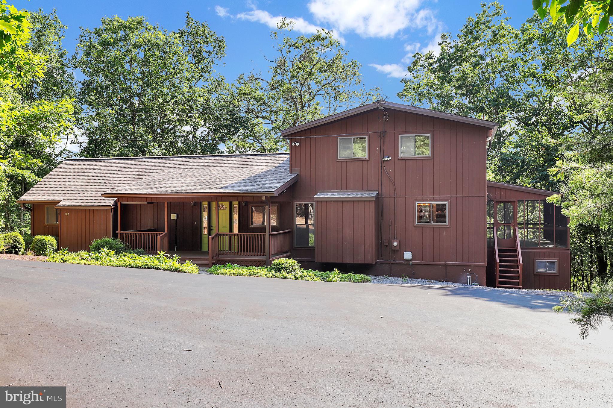 Welcome to 986 Walden Road, a meticulously updated retreat nestled within the serene woods of The Woods community in Hedgesville, WV. This expansive 3.87-acre property offers unparalleled privacy, backing to the 4th hole of the Stony Lick Golf Course and featuring a tranquil stream meandering through the landscape. With over $150,000 in recent upgrades, including a brand new roof, fascia and gutters on the main house and two car garage, this home seamlessly blends modern luxury with natural beauty. Home Highlights: Spacious Living: Boasting 2,974 sq. ft. of living space, this contemporary A-frame home features an open-concept design with vaulted ceilings and a majestic wall of windows that flood the interior with natural light. Gourmet Kitchen: The heart of the home showcases brand-new quartz countertops, a ceramic backsplash, and top-of-the-line stainless steel appliances, including a new washer and dryer, ensuring both style and functionality. Luxurious Bathrooms: The primary bathroom has been transformed with a new onyx shower and glass enclosure, while the second bathroom has been completely remodeled to offer a spa-like experience. Enhanced Comfort: Two new Aprilaire humidifiers have been installed on each furnace, and a new water softener ensures optimal water quality throughout the home. Energy Efficiency: A passive radon system has been implemented for peace of mind, and solar blinds with remote controls adorn the cathedral windows, offering both style and energy efficiency. Outdoor Living: Multiple decks, porches, and patios provide ideal spaces for outdoor entertaining and relaxation amidst the natural surroundings. Additional Structures & Amenities Two-Car Garage: A deep 24x32 ft. garage offers space for four cars, complemented by a 300 sq. ft. office and an additional 300 sq. ft. storage area beneath, perfect for equipment or vehicles. Three-Car Garage: Over 2,000 sq. ft. of garage and storage space, complete with a paved driveway, electric panel, and individual garage openers for each bay, ideal for hobbyists or car enthusiasts. Landscaping & Tree Removal: Recent dead tree removal and landscaping enhancements have been completed to further elevate the property's appeal and functionality. Location & Community: Situated in The Woods community, this home offers access to optional amenities such as golf courses, swimming pools, tennis courts, and a fitness center. The property is also within proximity to local shops, restaurants, and outdoor recreational activities, providing a perfect balance of tranquility and convenience. Don't miss the opportunity to own this exceptional property that combines modern upgrades with natural beauty. Schedule a private showing today and experience the charm of 986 Walden Road firsthand.