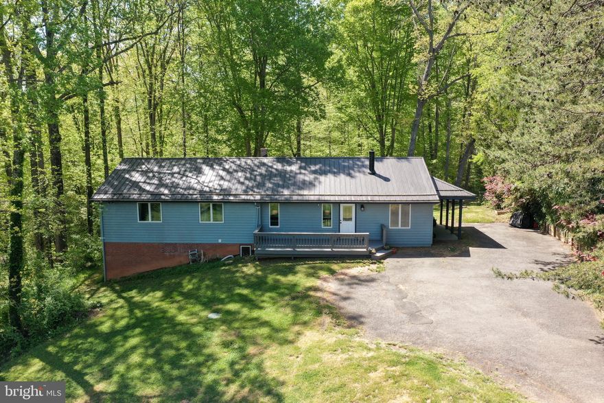 Virtual 3D & Aerial Video are now available. Welcome to your private country side living just minutes away from the city. Nestled on over 4.5 acres this country rambler is a rare opportunity to come by. No HOA. Fresh Paint, 2020 metal roof - 40 year warranty, 2021 hot water heater, 2018 Windows, 2018 Kitchen. Main level open floor plan welcomes you to large living room with cozy wood burning fireplace, updated modern kitchen with granite countertops and newer appliances and separate dining room. Down a step off living room, you will find a play room and an in home office. Four large sized bedrooms and two full bathrooms. Lower level features a large recreational room with scratch resistant, waterproof luxury vinyl plank, a kitchenette, separate laundry room, fifth bedroom, full bath, workshop, and a den. Ton of extra storage space throughout the home. Enjoy warm nights on maintenance free composite rear deck overlooking the privacy of your back yard. An abundance of trees and yard space will make you fall in love with this beautiful home. Minutes from Old Town Manassas, VRE, various shopping and dining centers. Close to major commuter routes, Prince William Parkway and 28.
