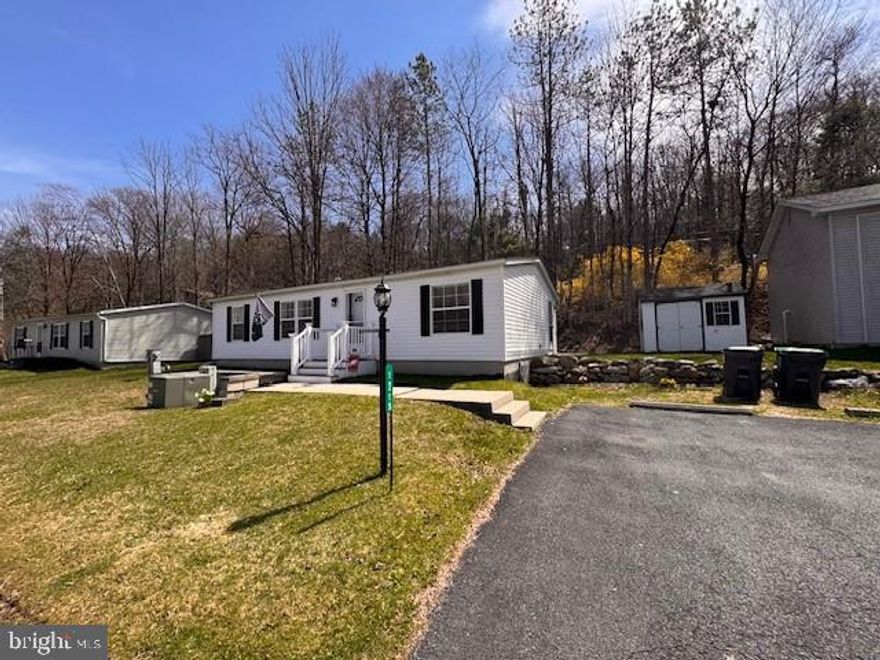 NOTHING TO DO BUT MOVE INTO THIS NEWLY RENOVATED 3-BR, 2-BA 2000 Fleetwood (1,056 sq. ft) ranch home located in the (55+ and older) community of Blue Mountain Village. You'll love the open floor plan allowing you to move freely throughout the home. RECENTLY RENOVATED! NEW Roof, NEW Central Air, NEW Propane Furnace, NEW Hot Water Heater, freshly painted rooms, NEW laminate flooring, NEW vanities, NEW faucets, NEW ceiling fans, just to name a few of the recent improvements! The ultra modern NEW kitchen features new cabinetry, countertops, tile backsplash, stainless appliances and with a center island that seats 2! The rear patio backs up to the woods for privacy! A detached shed and off street parking for 2+ cars! Blue Mountain Village is a 55+ retirement community. Monthly lot rent of $700 includes W/S, community club house with kitchen for hosting parties & family gatherings, gym & billiard club. Community surrounds a 9 acre catch and release lake. With the exception of the primary bedroom, living room TV and stand home being sold "FURNISHED"! This home is perfect as a main residence or your private getaway. BUYERS: Please make sure your approved for manufactured home financing . . VA, FHA, USDA or Conventional mortgages will not qualify for these homes. Looking to downsize? This is the Perfect Home! MOTIVATED SELLER! Call Today!