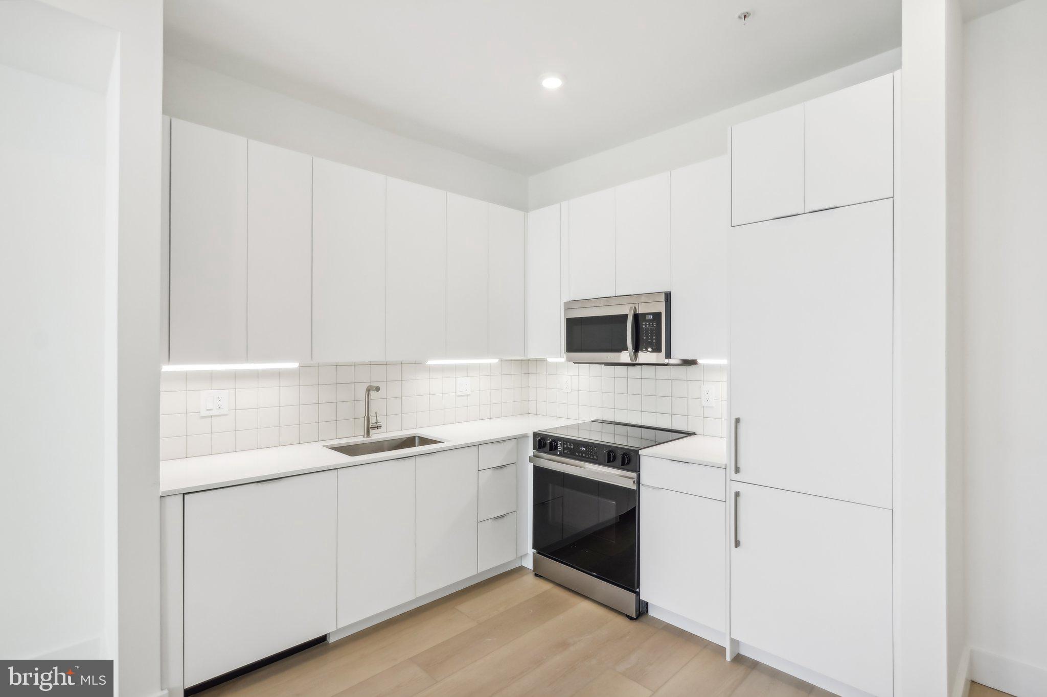 Welcome to 2406 Frankford Avenue, a stunning new construction building meticulously designed and developed by Archive Development. Price reflects 2 months free on a 14 month lease, base rent is $1625.
As you enter into the unit, you are welcomed by an abundance of natural light boasting from the massive factory-style windows. As you walk through the entryway and down the hall, you'll find the modern bathroom with white subway tile throughout the shower/tub combo, black delta finishes, and a floating vanity allowing for extra storage. The high ceilings throughout the living space continue into the bedroom which offers a large closet for storage, and ample space to comfortably fit a queen sized bed! The spacious, open concept kitchen and living area offers plenty of room for a sectional and/or dining table right by the enormous windows overlooking Frankford Ave. The European style kitchen is equipped with quartz countertops and panelized appliances. Full- sized washer and dryer in-unit for your convenience! Conveniently located to near all that Fishtown has to offer including Vessel Coffee Collective, Fiore, Martha, Philadelphia Brewing Company, Post Haste, Forin, and the brand new Picnic. Come see what Fishtown and 206 Frankford have to offer you! Pet friendly! Tenant pays electric and water. Please note photos are of a similar unit, floor plans vary but finishes are all the same.