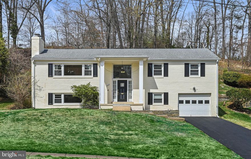 Fabulous location w one stop light to D.C. ! Bright and charming, all brick updated home in an established neighborhood. 4 BDRMS and 3 FULL baths. Lower bath recently updated with glass shower doors. Kitchen with SS appliances and granite countertops. Hardwood floors on the upper level and brand new wood laminate flooring in the family room and lower level bedroom.  The very large Family room with a second wood burning fireplace is perfect for relaxing. The dining room and kitchen open to a charming stone patio backing to a lovely wooded area. The built-in shelves and a wood-burning fireplace add a cozy touch to the living area. The main level includes 3 of the 4 bedrooms.   The garage can be used as a workshop, with built in shelves and working bench.. The lower level is great for visitors with a 4th bedroom and a 3rd full bath. All this and an attached garage! Minutes to the Beltway and Tysons!