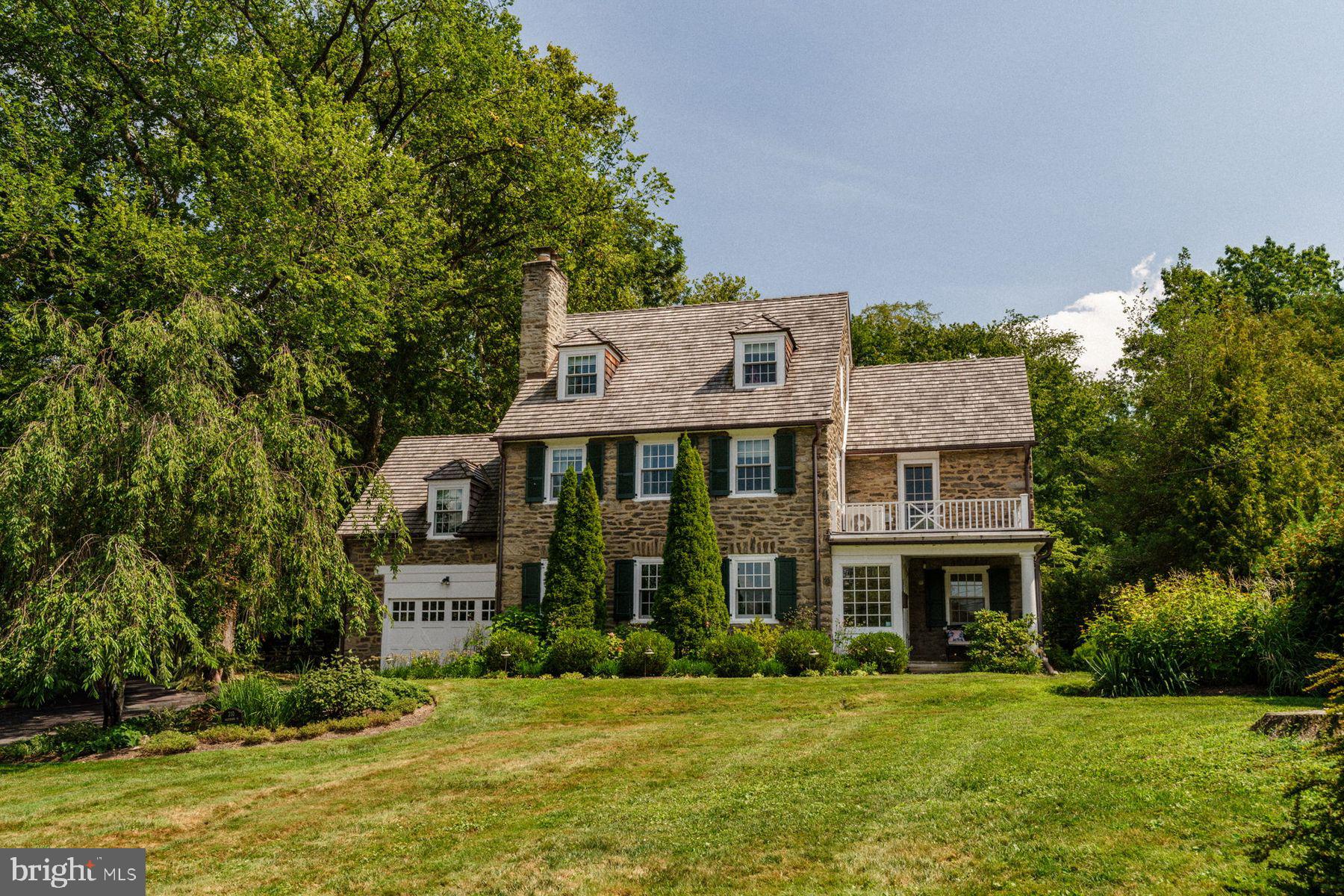 Colonial Revival in Chestnut Hill’s Coveted Arboretum Neighborhood
Colonial Revival in Chestnut Hill’s coveted Arboretum neighborhood. This beautifully sited 1927 stone home features 5 beds, 3.5 baths, and offers just under 4,000 sq ft of living space on a private 0.56-acre lot. The classic slate roof, original millwork, hardwood floors, and built-ins reflect timeless craftsmanship, while tasteful updates add modern comfort. A newly renovated kitchen, family room, and mudroom addition, expertly designed and built by Meyer Construction, offers high-end finishes and exceptional functionality. The spacious family room with fireplace opens to a stone terrace overlooking tranquil woodlands. Light-filled bedrooms on the upper level include charming sloped ceilings; updated baths offer fine fixtures and a neutral palette. Includes a private entrance to the Morris Arboretum and just minutes away from Erdenheim Farm, the scenic Wissahickon trails, Chestnut Hill’s charming shops and acclaimed restaurants. Easy access to Center City and Manhattan via regional rail. A rare opportunity in one of Philadelphia’s most historic neighborhoods!