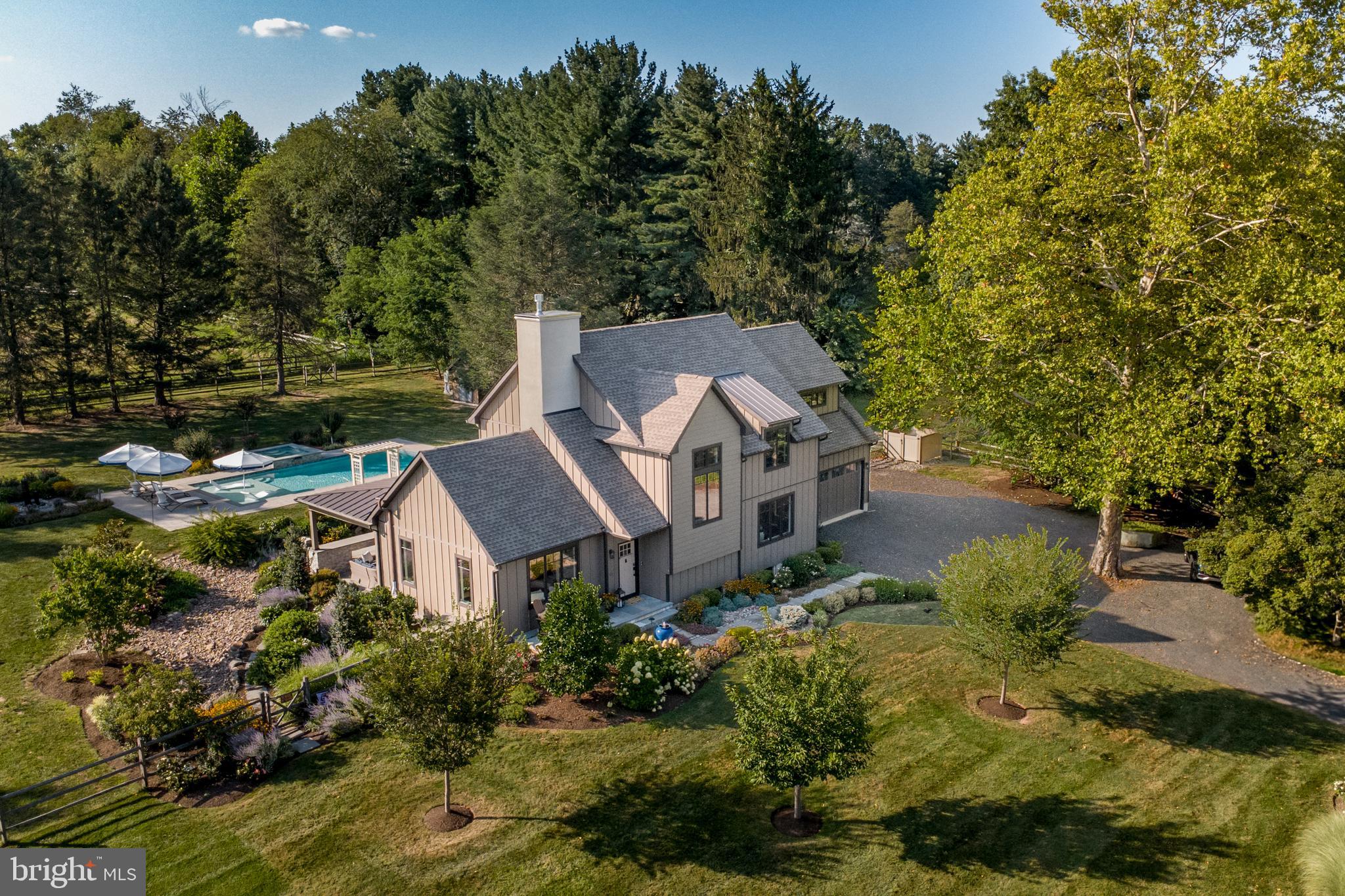 You CAN have it all and there is nothing to do but move in! Stunning, sophisticated and special describes this contemporary farmhouse that in 2000 was totally rebuilt from the foundation up. Everything is five years old, including the septic system, and the products, materials, and craftsmanship are of the highest standards. Step into the foyer and you immediately see a unique floor plan ideal for relaxed comfort and small and large gatherings. Ceilings on the first floor are 9’ and in the living room and family room, each with a gas fireplace, they are 11’. A few of the notable features are ¾” hardwood floors throughout, Craftsman style windows everywhere, contemporary lighting fixtures, three full bathrooms, a possible first floor bedroom, and a wow backyard built to enjoy maximum time outdoors. The foyer is open to a spacious living room with a sliding door to the covered patio addition. The centrally located dining room is between the living room and the kitchen that has lots of custom made inset cabinetry in a custom color. White Quartz counters, Sub-Zero refrigerator, Wolf 6-burner 36” range and a huge island with farm sink and seating, the kitchen flows into the family room and this huge area is the gathering place and heart of this home. Another double sliding door takes you to the covered bluestone patio and to the exquisite pool and spa area. From the left of the staircase is a hall that has a large office that could be used as a first floor bedroom, a full bathroom with an enormous walk-in shower and a door to the huge unfinished basement with Bilko door on the side of the house. Upstairs is the primary suite with 11’ ceiling, 3 closets, an ensuite bathroom with freestanding soaking tub and oversized walk-in shower. Two other bedrooms, a hall bathroom and laundry area complete the second floor. To match the ambiance and beauty of the interior, the seller took the bare land and created exterior living space costing more than $400,000. No expense was spared to make the outside part of the appeal of this gracious home. The 1.5 acres were professionally landscaped and hardscaped. There is continuous flowering and color in every season and lighting, fountains and specimen trees dot the grounds. The saltwater pool has a sun shelf to relax on in the water and the large hot tub features a waterfall spilling into the pool. The 30’ covered patio was built to provide 3-season enjoyment with heaters and fans in the wood ceiling, recessed lighting, wired stereo system, and a mechanism for a TV. The gas fireplace built into the stone wall has a remote that can change the fire color and there is also one to change the color of the pool water. Beautiful, fun, and incredible ambiance! This private oasis is in a great location near Doylestown, Peddler’s Village, and New Hope with the finest Bucks County amenities. Stores, restaurants, boutiques, museums, a train station, movie theater, playhouse, parks and accessibility to commuting routes. Maximuck’s Farm Market & Gardens is across the street and it is their farm that is preserved and can never be built on. The view from the front of this home is farmland and goats and wildflowers in the summer months. This home is luxury living indeed. Welcome home to your own private slice of paradise!