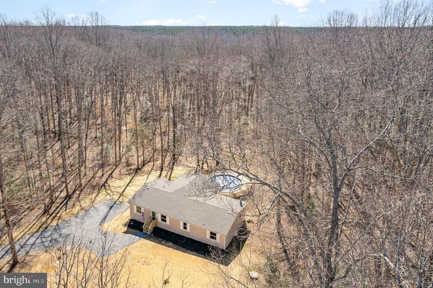 Come home to a peaceful, wooded country retreat with a large front lawn just 6 miles from 95!   This outdoor oasis is complete with a screened-in porch, a pool with a large deck and a recently replaced liner.  There are  5 acres of woods to explore leading down to the Ta River water frontage!  This property is a dream for an outdoorsman or someone  who loves to host gatherings!  

The home has a great layout with a view of both living rooms and the dining room from the kitchen.  A split bedroom design with the primary suite separated from the secondary bedrooms.

The home is renovated to include a new roof, new flooring, paint, cabinets, new vanities, lighting and new quartz countertops in the kitchen.