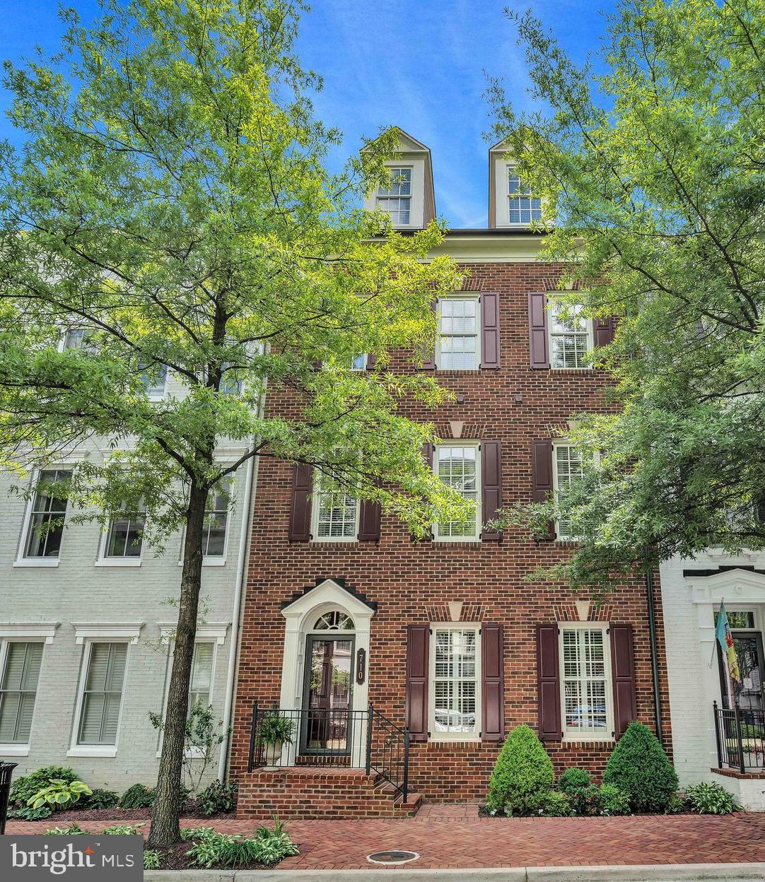 Welcome to 710 Miller Lane—a refined brick townhome nestled on a tree-lined street in one of Alexandria’s most distinguished enclaves, Potomac Greens. This rarely available Fairfax model by EYA offers over 3,600 square feet of beautifully finished living space across four thoughtfully designed levels. With four spacious bedrooms, three full and two half baths, and exceptional natural light throughout, this home blends timeless architecture with modern elegance and versatility.
The main living level is designed to impress, offering gracious spaces for both elevated daily living and seamless entertaining. Elegant hardwood floors, soaring ceilings, and detailed crown molding set the tone, while the chef’s kitchen features granite countertops, stainless steel appliances, a five-burner gas cooktop, double wall ovens, and a large center island with a breakfast bar setting—perfect for casual dining. The kitchen flows effortlessly into the breakfast area, dining room, and family room—creating a welcoming and functional layout. Both the family room and the lower-level library/recreation room feature gas fireplaces with slate hearths and classic mantels, flanked by built-in cabinetry that adds architectural charm and warmth. Adjacent to the breakfast area, a private terrace with a dedicated gas line offers an inviting space for outdoor dining or seasonal entertaining.
The luxurious owner’s suite offers a serene escape, complete with a separate sitting area, two walk-in closets (including one with a thoughtfully designed custom system), a private terrace, and a spa-inspired bath featuring Kohler fixtures, a soaking tub, and a spacious shower. Additional flexible spaces include a main-level private study, a lower-level library or recreation room, and a top-floor loft that opens onto an expansive rooftop terrace—ideal for relaxing or entertaining under the open sky.
Additional highlights include a finished two-car garage with keypad entry, dual-zone HVAC, an upper-level laundry room, generous storage, and multiple private outdoor living spaces.
Set within the highly sought-after Potomac Greens community, this home offers unparalleled convenience to Amazon HQ2, the Virginia Tech Innovation Campus, and the Potomac Yard Metro station. Community amenities include scenic nature trails, brick-paved sidewalks, a stately clubhouse with meeting and party rooms, a fitness center, heated outdoor pool, landscaped pocket parks, and tot lots.
Just minutes from Old Town Alexandria’s waterfront, the shops and restaurants of Del Ray, and with easy access to the George Washington Parkway and Mount Vernon bike trail, this location also provides quick connectivity to I-495, I-395, and I-95. Only two traffic lights to downtown D.C. and Reagan National Airport—offering both accessibility and distinction.
This is a rare opportunity to own a truly exceptional townhome where timeless craftsmanship meets modern luxury—delivering an unparalleled lifestyle in one of Northern Virginia’s most desirable communities.