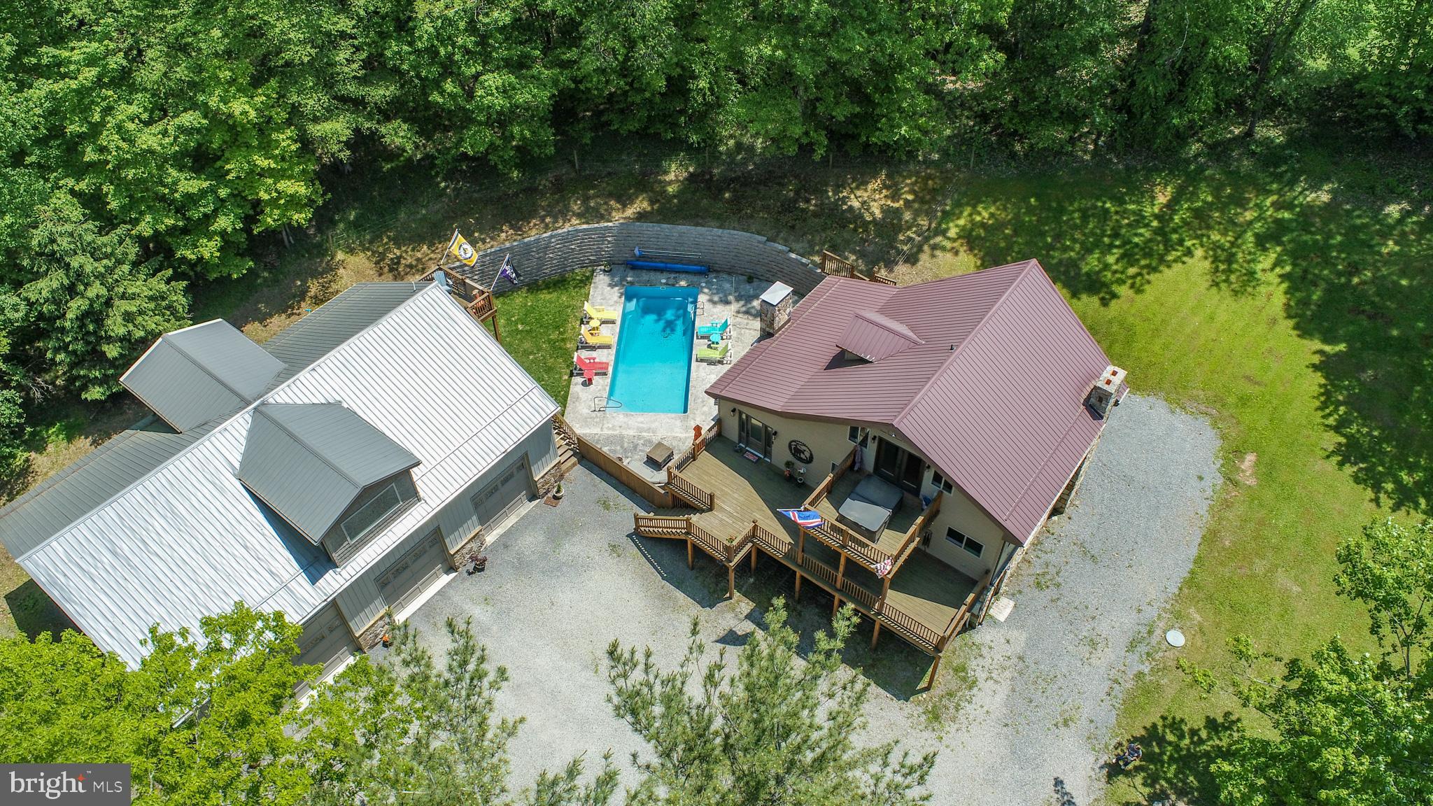 Recently updated in 2021, this home features modern finishes, premium hardwood floors, and upgraded systems throughout. Located next to Wisp Resort and Fantasy Valley golf course, this property is just minutes from everything Deep Creek Lake has to offer! Step into your private oasis featuring an incredible outdoor patio with a luxurious saltwater pool. The patio is complete with a hot tub, a wood burning fireplace, outdoor bar, and plenty of lounge seating. It's resort style living right in your own backyard. The main house is 4 bedrooms and 3 full bathrooms with just under 3,000 square feet of living space. The kitchen features top-of-the-line appliances, custom cabinetry, and an island perfect for setting up food. Designed for both style and function, it’s a chef’s dream—where gourmet meals and everyday living come together effortlessly. The primary bedroom features a hot tub on the balcony, perfect for a relaxing movie night. All bathrooms have been beautifully updated and appointed. Downstairs is the perfect place to enjoy any sports game. There is a game table, pool table and a second living room perfect for game night! The massive 38ftx50ft (2,272 sq ft) heated garage offers so much space for storage or a workstation with an apartment/in-law suite above. The sellers currently have the space above the garage setup as a 3 bedroom (no egress) and 1 full bathroom. This property is located outside of zoning, so the new owner can decide what they wish to do with this amazing space! Please contact me today to schedule a private tour of this McHenry oasis!