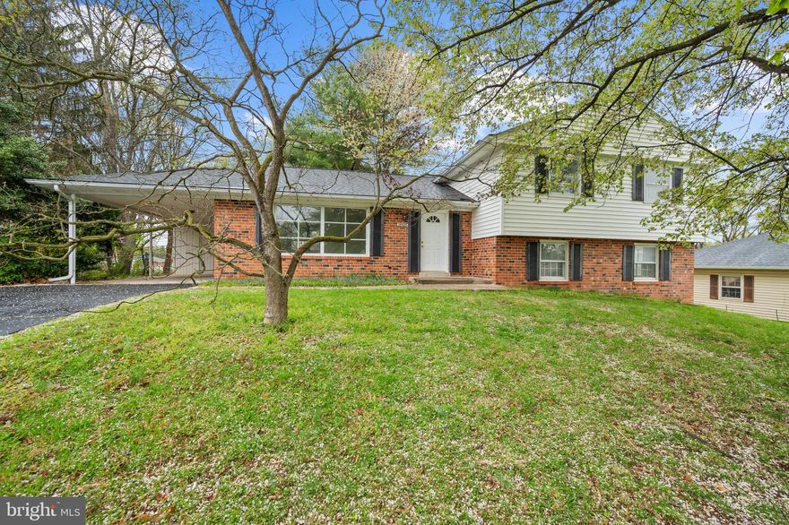 Charming brick-accented split-level residence offering 2,277 square feet, featuring 4 bedrooms, 2 full bathrooms, 1 half bath, and a 1-car carport lovingly maintained by the original owners in desirable Olney Mill. A spacious traditional floor plan on the main level begins in the welcoming foyer and flows into a large living room that opens seamlessly to the formal dining room, enhanced by a classic chandelier and side access to the exterior. The bright, white eat-in kitchen is both stylish and functional, boasting stainless steel appliances, quartzite countertops, a peninsula breakfast bar, and ample cabinet storage. Upstairs, you'll find 3 generously sized bedrooms with hardwood flooring and two full bathrooms. The primary suite includes an ensuite bath complete with dual sinks, a separate water closet, and a shower accented with a custom tile floor pattern. The lower-level recreation room offers a cozy wood-burning fireplace with a brick surround, porch access, a convenient half bath, a 4th bedroom, a versatile bonus room or 5th bedroom, and a laundry room with an additional porch entrance.  The lowest level features a flexible recreation space—ideal for storage, hobbies, or future customization. Outdoor living is just as inviting, with a screened-in porch and a large, open-fenced backyard.