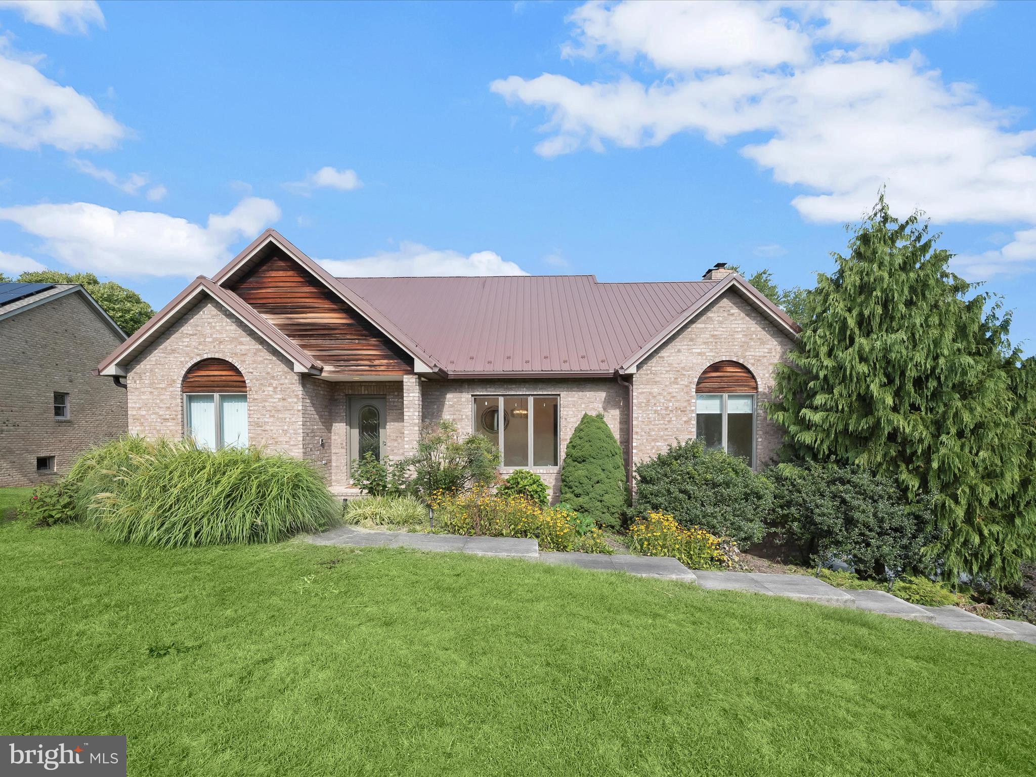 Welcome to 10642 Hershey Drive, an elegant custom-built all-brick home in the desirable Van Lear Manor community, perfectly situated on a 0.68-acre lot with beautifully landscaped grounds and a striking metal roof. The inviting foyer is flanked by formal living and dining rooms, setting the tone for the home’s timeless design. The eat-in kitchen offers ample cabinetry, a curved center island with a prep sink and breakfast bar, and easy access to the two-story family room. Here, soaring cathedral ceilings, a cozy brick-profile fireplace, and dual access to the expansive deck create the ideal space for gatherings. The main-level primary suite is a true retreat, featuring a walk-in closet, private deck access, and a spa-like en-suite bath with dual vanities, a soaking tub, skylight, and glass-enclosed shower. A second bedroom or private office and a powder room complete this level. Upstairs, you’ll find two spacious bedrooms, a full bath, and a versatile loft overlooking the family room. The unfinished lower level offers endless possibilities with a rough-in, walkout access to the covered patio, and garage entry. Combining classic craftsmanship, thoughtful design, and a picturesque setting, this home is a rare find. Some photos have been virtually staged