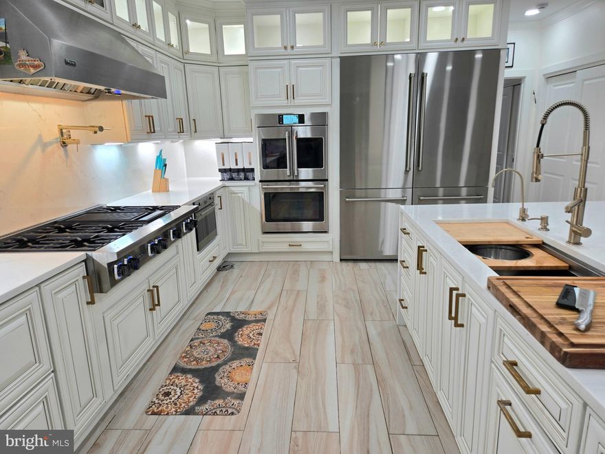 Stunning Fully Upgraded Smart Home with Premium Modern Finishes

$600K+ Upgrades in 2025| 5,500+ Sq Ft | Turnkey Luxury

Welcome to this exceptional East‑Facing Cambridge model in Chantilly, offering 5,500+ sq. ft. of sun‑drenched, thoughtfully designed living space. Fully renovated inside out in 2025, this residence showcases premium finishes, energy‑efficient systems, and an impressive suite of WiFi‑enabled smart‑home Appliances and features, Brand New Windows and Doors, New Composite Deck, advanced safety locking systems, smart thermostats, perimeter cameras and adjustable LED ambiance lighting throughout. With its expansive front yard, refined upgrades, and uniquely crafted floor plan, this home delivers a seamless blend of modern luxury, comfort, and everyday functionality.

First Level : Step into an inviting foyer that sets a refined and memorable first impression, unfolding into a stately, sun‑drenched formal living room anchored by an elegant gas fireplace. A beautifully appointed main‑level bedroom with a full standing shower adds exceptional versatility—perfect for guests, extended family, or a private work‑from‑home retreat. A dramatic 16‑foot, six‑panel glass bifold door opens completely to reveal an expansive 30‑foot deck, creating a seamless indoor‑outdoor flow into the serene, thoughtfully landscaped backyard oasis—an idyllic setting for gatherings, relaxation, and elevated everyday living.

At the heart of the residence lies a sophisticated chef’s gourmet kitchen, meticulously crafted with premium finishes, high‑performance appliances, and an intuitive layout designed for both culinary mastery and effortless entertaining. A commanding 15‑foot waterfall quartzite island offers seating for ten and serves as a stunning centerpiece for celebrations and everyday enjoyment. Matching quartz countertops and full‑height backsplashes wrap the space in refined elegance. A curated suite of professional grade appliances elevates every culinary experience with a Kitchen triangle Design template: a Viking 48” six‑burner gas range with commercial hood, a ZLINE 60 inch double‑door refrigerator, multiple BOSCH and Fisher & Paykel dishwashers, ZLINE stacked double ovens, a beverage cooler, and a 60‑bottle wine cooler—all Professional appliances selectively picked for exceptional performance, Speed and effortless hosting. Luxury continues with a designer pot filler, an integrated microwave/oven combo, a 44” stainless‑steel prep‑station sink, a hammered copper secondary sink, and a Brizo tankless 6‑stage reverse osmosis system for pristine drinking water setup. Custom flush‑mounted cabinetry, under‑cabinet LED lighting, and illuminated display cabinets add architectural sophistication, while sleek porcelain flooring completes the modern, gallery‑like aesthetic.

Upper Level: showcases four spacious bedrooms, three fully remodeled en‑suite bathrooms, and a thoughtfully designed private office. Each bathroom has been elevated with ceiling height luxury porcelain tile, custom solid‑wood cabinetry, and recessed lighting across all rooms, creating a bright atmosphere. The primary suite impresses with high ceilings, generous proportions, and a serene spa‑like en‑suite bath featuring seamlessly integrated second‑level laundry access—a rare and refined convenience. A creative redesign also introduces a private office, ideal for work, study, or a quiet personal retreat.
Lower Level: The lower level offers a spacious, relaxing retreat complete with a fifth full bathroom, a second laundry room, and abundant storage. This versatile area provides the perfect setting for recreation, extended‑stay guests, or a private getaway within the home.
Backyard & Exterior:  Set on a generous 0.49‑acre lot, the property offers an exceptional outdoor living experience. A 30‑foot, long‑lasting composite deck (built 2025) extends the entertainment space.