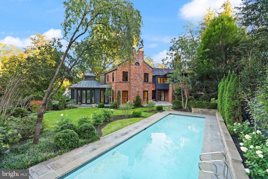 A rare offering where luxury, technology, and wellness converge, 3525 Springland Lane NW is a private resort-style residence reimagined to perfection in the heart of Washington, DC’s highly sought-after Cleveland Park neighborhood. Originally built in 1937 and completely reimagined in 2025, this architectural gem combines timeless character with the best of modern living. A statement entry sets the tone for the home’s artful composition—a grand foyer and gallery aligned with three steel-framed glass doors that open to the terrace, gardens, and heated pool beyond, creating a breathtaking sense of symmetry and light. The main level showcases formal living and dining rooms, an elegant office with custom built-ins, and a showstopping chef’s kitchen with dual Sub-Zero refrigeration—one full refrigerator and one full freezer—premium appliances, glorious white polished marble counters, a large butler’s pantry, and a bar with both a wine cooler and beverage refrigerator. The adjoining breakfast sunroom opens to a terrace shared with the kitchen for seamless indoor-outdoor entertaining. Throughout the home, bespoke architectural and decorative lighting fixtures serve as functional works of art, complemented by refined millwork and designer finishes. Integrated smart-home technology and built-in speakers offer modern convenience and comfort. Upstairs, every bedroom includes an en suite bath, while the serene primary suite features vaulted ceilings and a spa-quality bath with soaking tub and oversized shower. The lower level offers a full media room, wellness center with infrared sauna, and a private guest or au pair suite with kitchenette and separate entrance. Enhancing the home’s wellness-forward design are a Culligan whole-house water softening system and a backup generator for comfort and peace of mind in every season. An attached two-car garage with mudroom, French white-oak floors, and all-new systems complete this extraordinary residence. Set on a sizable 0.49-acre lot with approximately 6,000 interior square feet, this home offers the perfect balance of privacy, space, and design—just moments from top schools, shopping, and dining.
