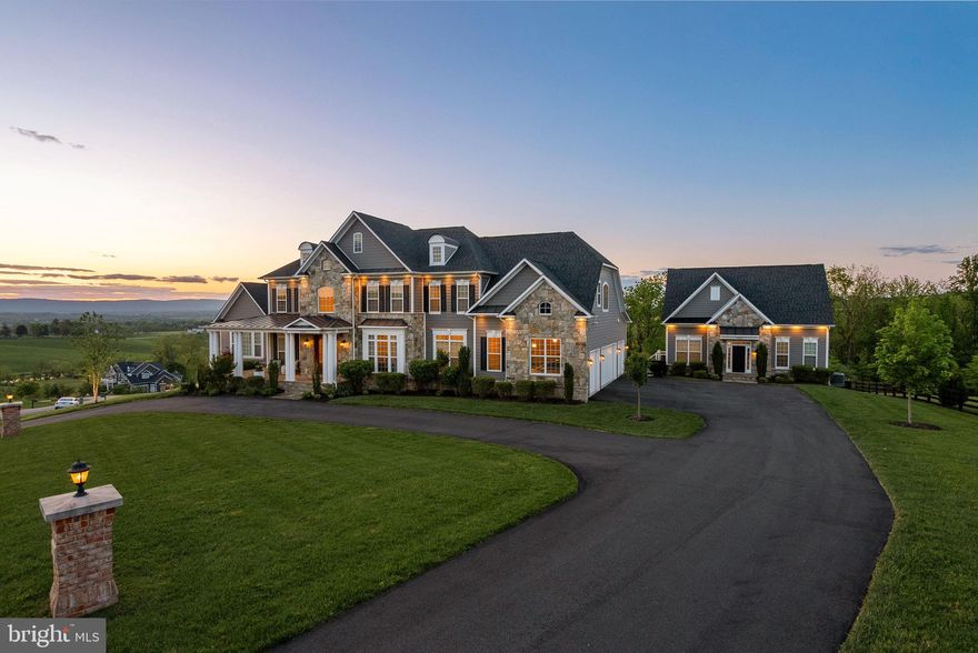 Once-in-a-Lifetime Estate with Breathtaking Views, Resort-Style Pool, and Charming Guest House 

Rarely does a home of this caliber—offering unmatched beauty, expansive space, and sweeping views of the Blue Ridge Mountains, vineyards, and rolling farms—come available this close to Leesburg. This is a rare opportunity to wake up to spectacular sunrises, unwind by your private pool at sunset, and experience the finest in Loudoun County living—all from the comfort of two meticulously designed residences on one extraordinary property.

The main home, a luxury Carrington-built estate, combines timeless elegance with modern flexibility, featuring 5 bedrooms, 4.5 bathrooms, 4 car garage with EV fast charger, and a sun-filled finished lower level. Rich engineered hardwood floors run throughout, and a gourmet kitchen anchors the heart of the home with white cabinetry, marble countertops, a pot filler, stone backsplash, extended 10 foot island, upgraded appliances, and vaulted keeping room.

A dramatic two-story foyer with custom millwork leads to an arched art gallery-style hallway. The expansive main level includes formal living and dining rooms, large mudroom area, secluded library with double glass doors, and a spacious family room with a stone fireplace, coffered ceilings, opening to a screened in porch and deck—perfect for outdoor dining and entertaining. The art gallery leads to a vaulted club room, complete with plantation shutters and stunning views.

The luxurious primary suite features a private sitting area, morning bar, dual walk-in closets, and a spa-inspired bath with soaking tub and a double shower. Upstairs, you’ll find a princess suite with a private bath, two additional bedrooms with an adjoining Jack & Jill bathroom, and a conveniently located laundry room.

The walkout lower level offers even more living space, including a game room, full wet bar, two guest bedrooms with a full bath, customized fitness area, and direct access to the backyard oasis.

Step outside to your own private resort, featuring an inground pool with spa and waterfall, covered patio, elegant paver surround, large fire pit, and a spacious garage shed. Professionally designed outdoor living spaces and landscape make this home perfect for both relaxing and entertaining.

The three-level guest house is equally charming and versatile,  with it's own street address, offering   2 bedrooms, 2.5 bathrooms, a modern kitchen, comfortable living space, and basement. This additional home is ideal for guests, an au pair, multigenerational living, or possible rental opportunity.

Located just minutes from historic Waterford and downtown Leesburg, with access to top-rated schools, local wineries and breweries, shopping, hospitals, the Dulles Greenway, and Dulles Airport—this property truly embodies the best of Loudoun County living.

Schedule your private tour today—homes of this preeminence and location are a rare find.