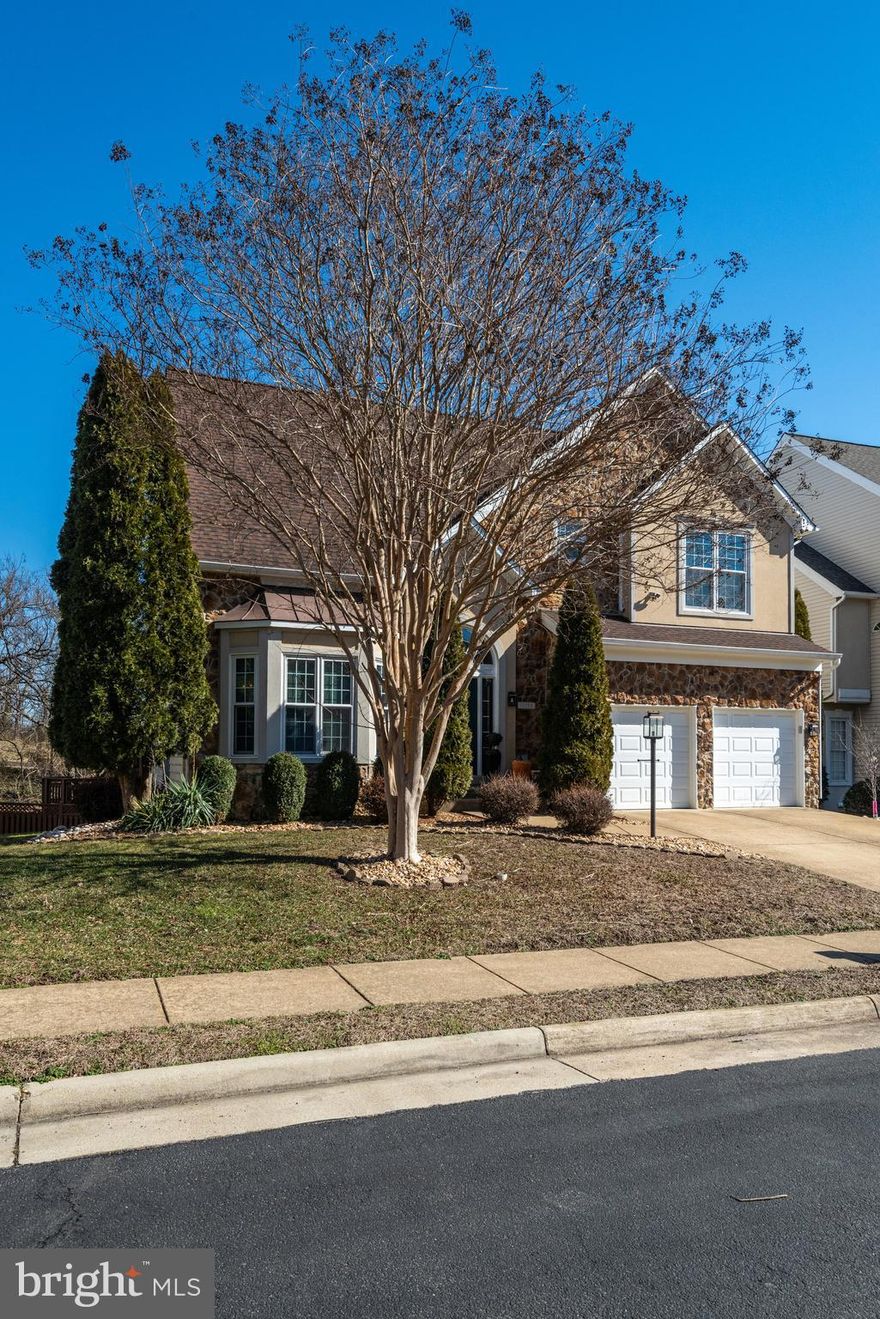 Discover this stunning home in Belmont Bay, featuring 4 bedrooms and 3.5 bathrooms. The upgraded exterior showcases beautiful stone and stucco. Step into the grand foyer with an impressive staircase and hardwood floors, leading you to the formal living and dining rooms. The back of the house offers scenic views of the Potomac River and surrounding park space. The spacious family room boasts vaulted ceilings and a cozy fireplace, while the eat-in kitchen features stainless steel appliances, a large island, and plenty of cabinet space, all overlooking a large deck. Enjoy seasonal views of the river and the privacy of green space and trees. Adjacent to the family room is a well-appointed office. 

Upstairs, the owner's suite is a true retreat, complete with a luxurious bathroom featuring double vanities, a soaking tub, a separate shower, and a double-sided gas fireplace that adds ambiance to both the bedroom and bathroom. A private deck off the suite is the perfect spot for morning coffee. Two additional bedrooms and a double vanity hall bathroom complete the upper level, with an open hallway overlooking the family room below.

The fully finished lower level offers a fourth bedroom and a full bath, along with a large recreation room and built-in bar, perfect for entertaining. The expansive, fenced yard features a patio and pergola—an ideal spot for relaxing in nature after a long day. The neighborhood is just minutes from the VRE, Amtrak, and bus services for easy commuting. Community amenities include a full-service marina, pool, tot lot, tennis courts, and scenic walking trails.