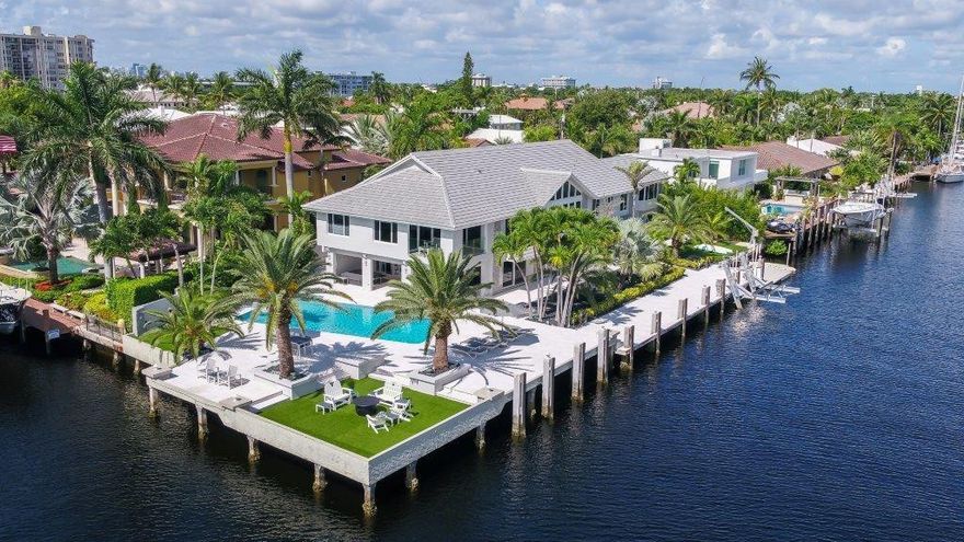 View filled Intracoastal Point Lot estate offering 239' deepwater with 179' on wide side canal providing multi yacht dockage. Updated and move in ready including impact glass, porcelain tile floors, new kitchen and dramatic 2 story living room with loft and elevator. Custom wet bar opens to family room and covered Lanai.  Separate living area for live-in / mother in law suite. Large view filled master retreat. Expansive outdoor entertaining area with large heated pool on oversized point lot. Must see!.